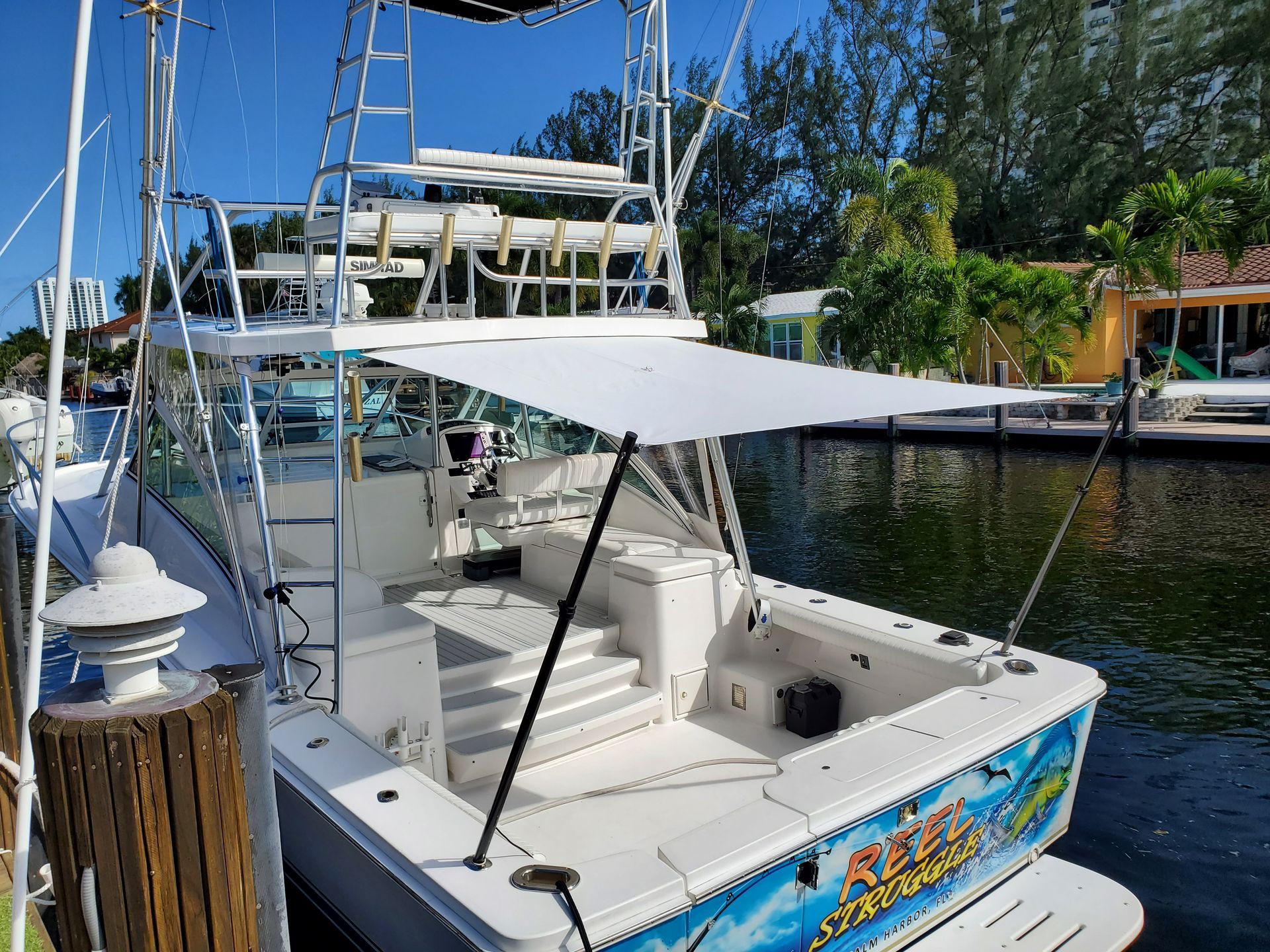 A boat with a canopy on top of it is docked at a dock.