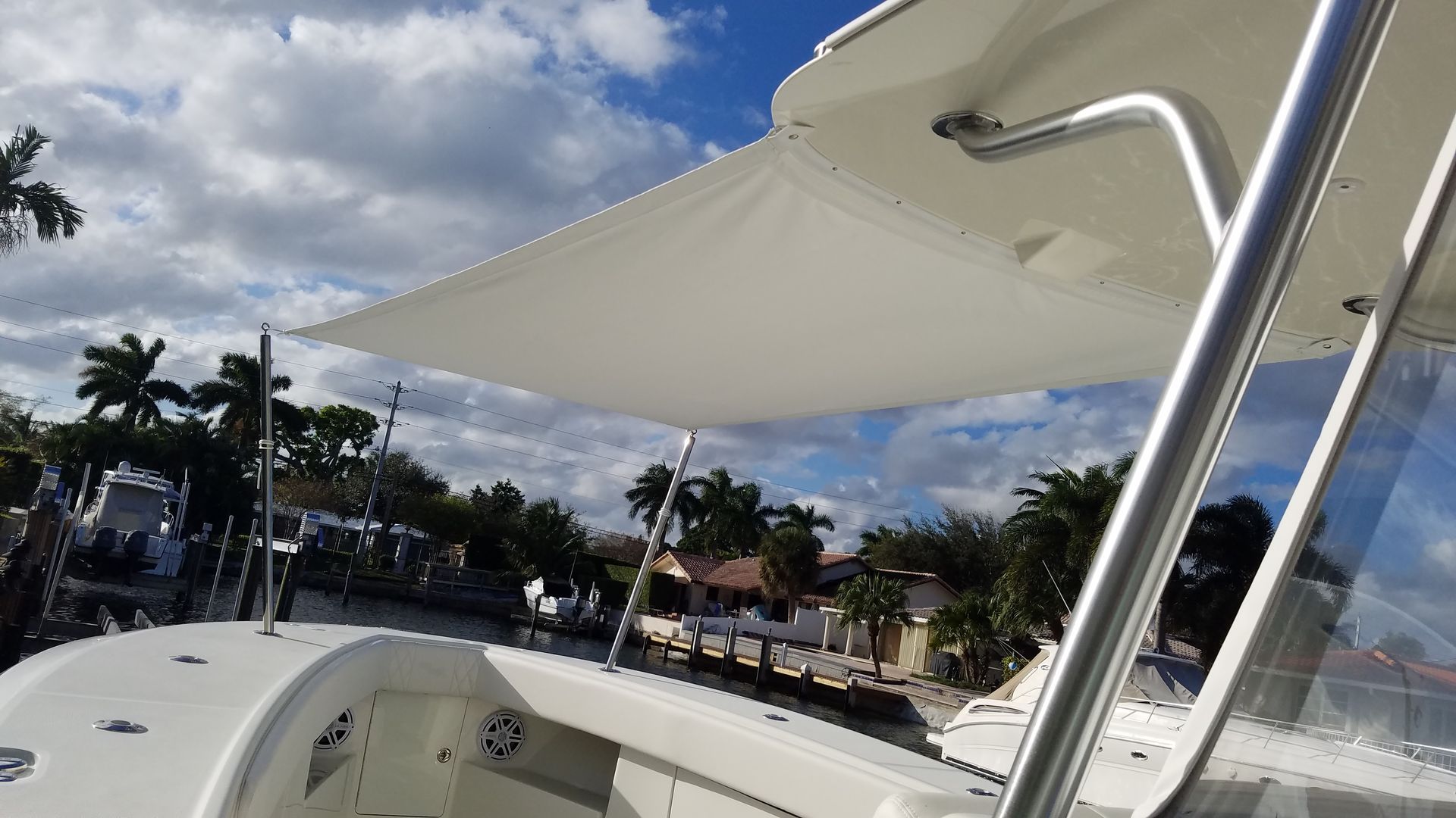 A white boat with a white umbrella on top of it.