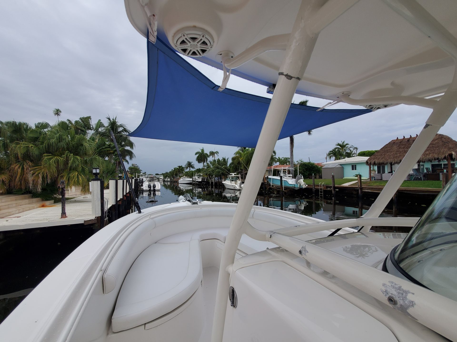 A white boat with a blue umbrella on top of it