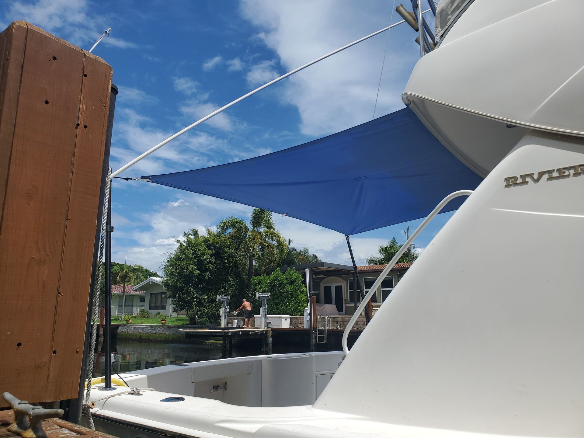 A white boat with a blue sail on top of it