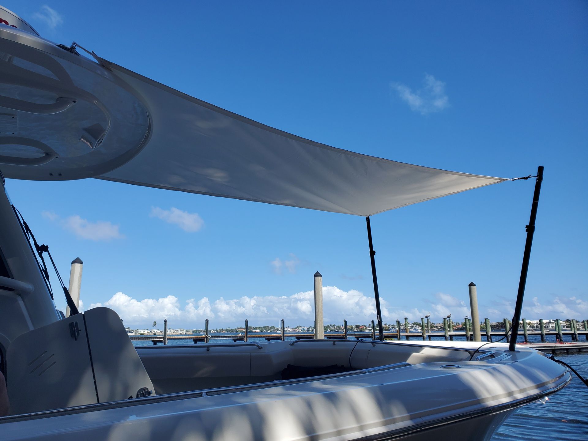 A boat is docked at a dock with a canopy over it