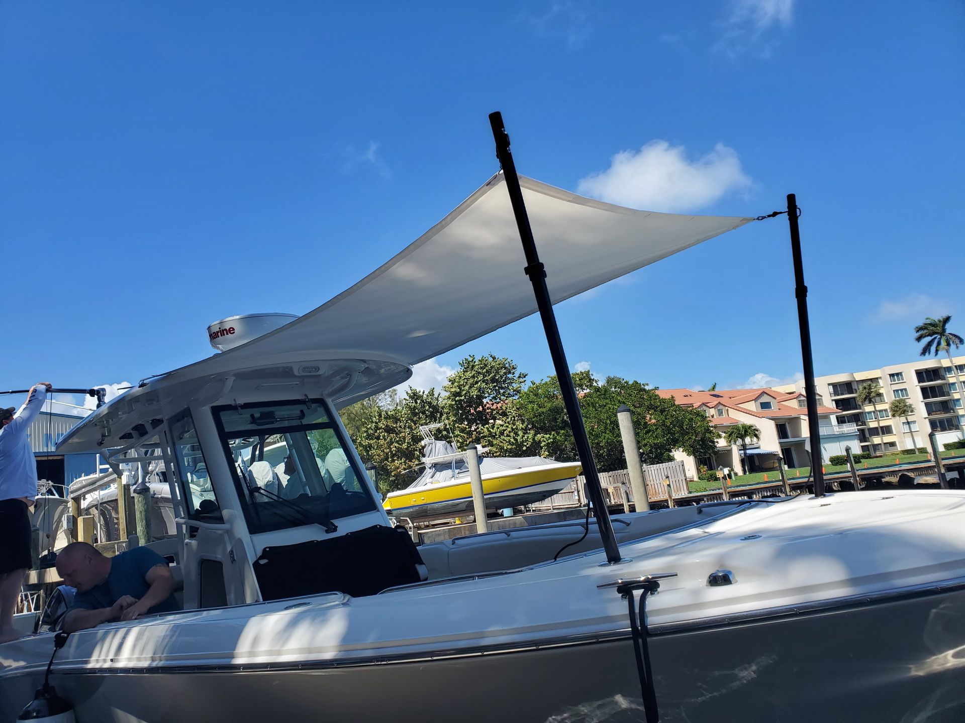 A boat with a sail on top of it is docked in a marina.