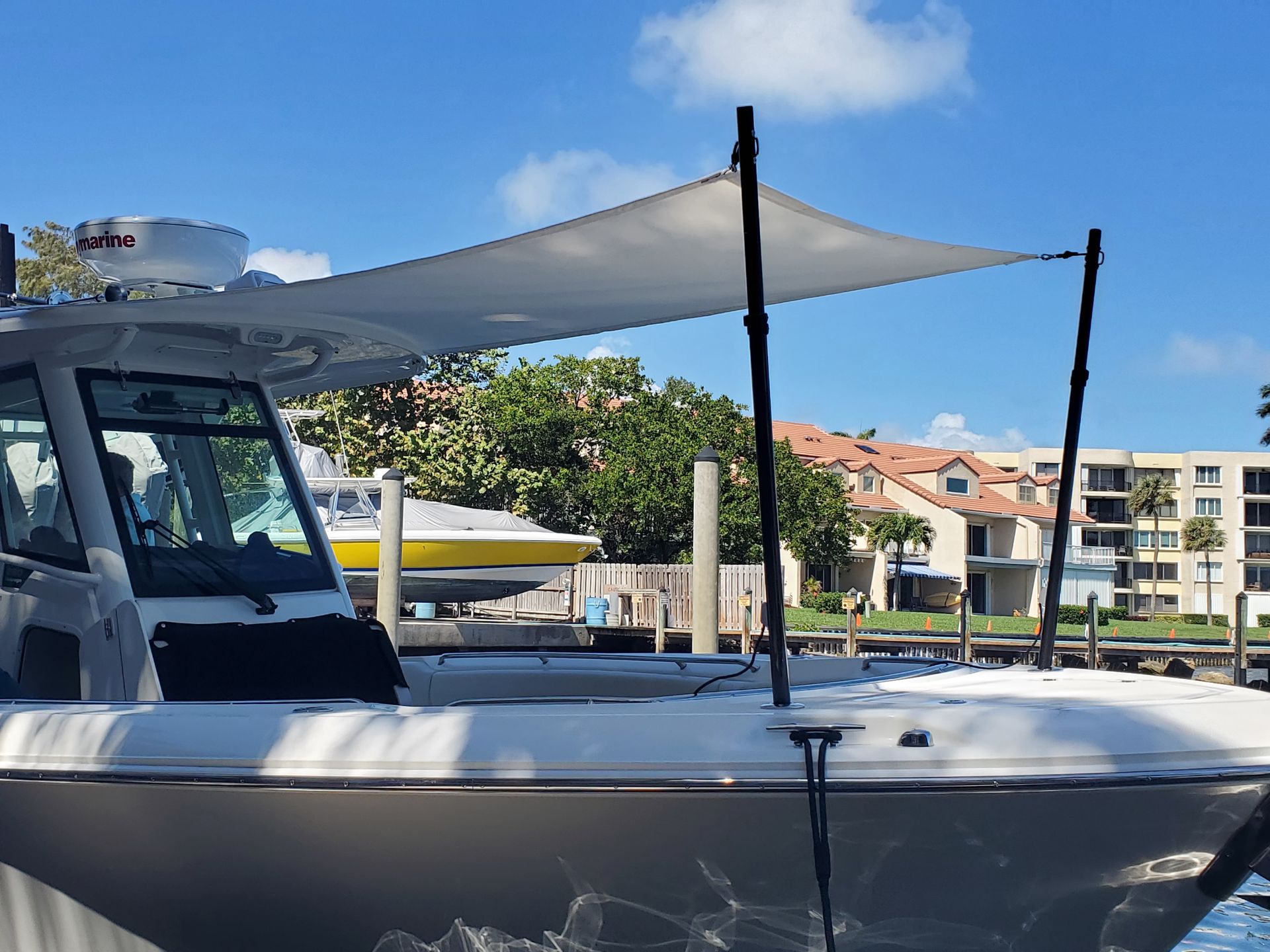 A boat with a sail attached to it is docked at a dock.