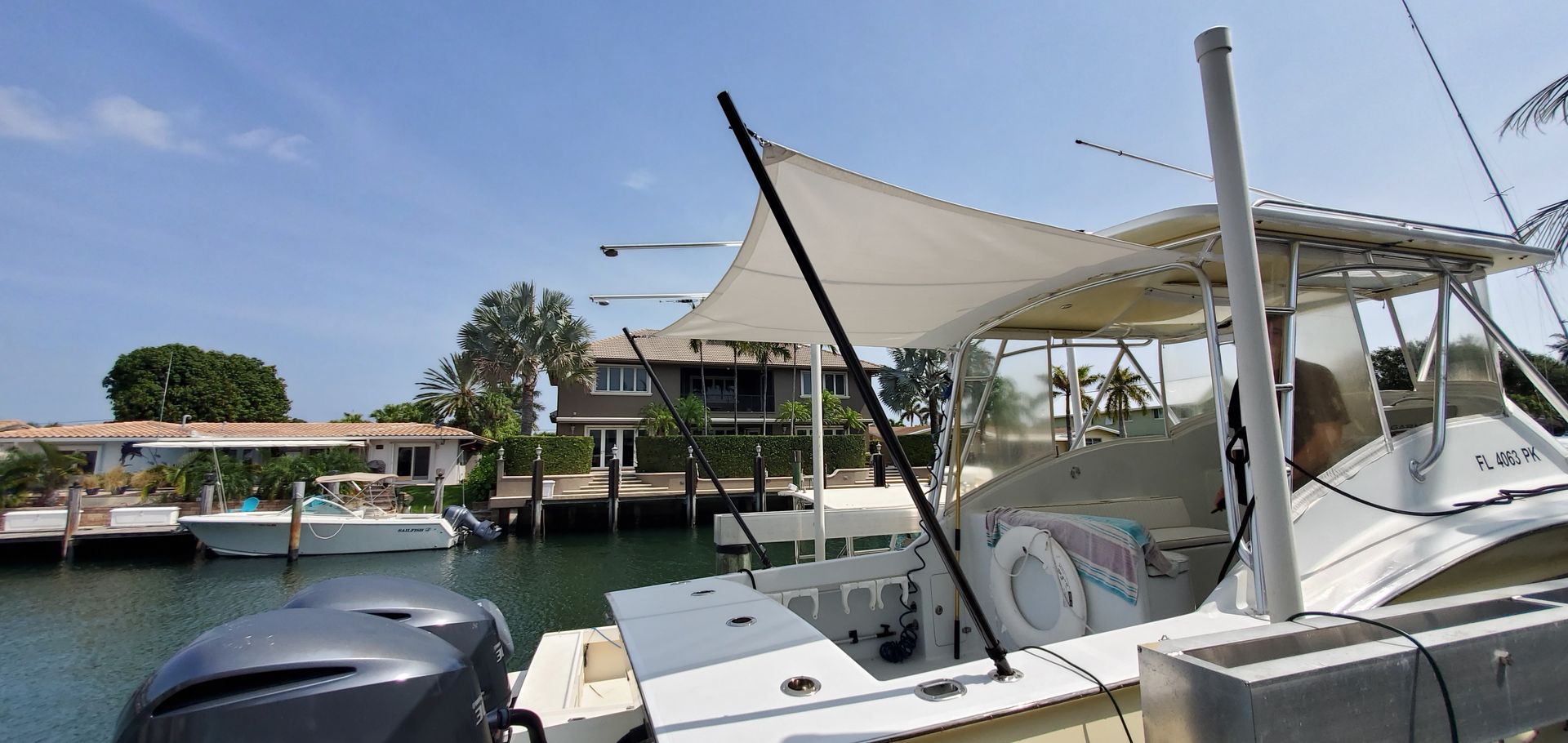 A boat is docked in a harbor with a house in the background.