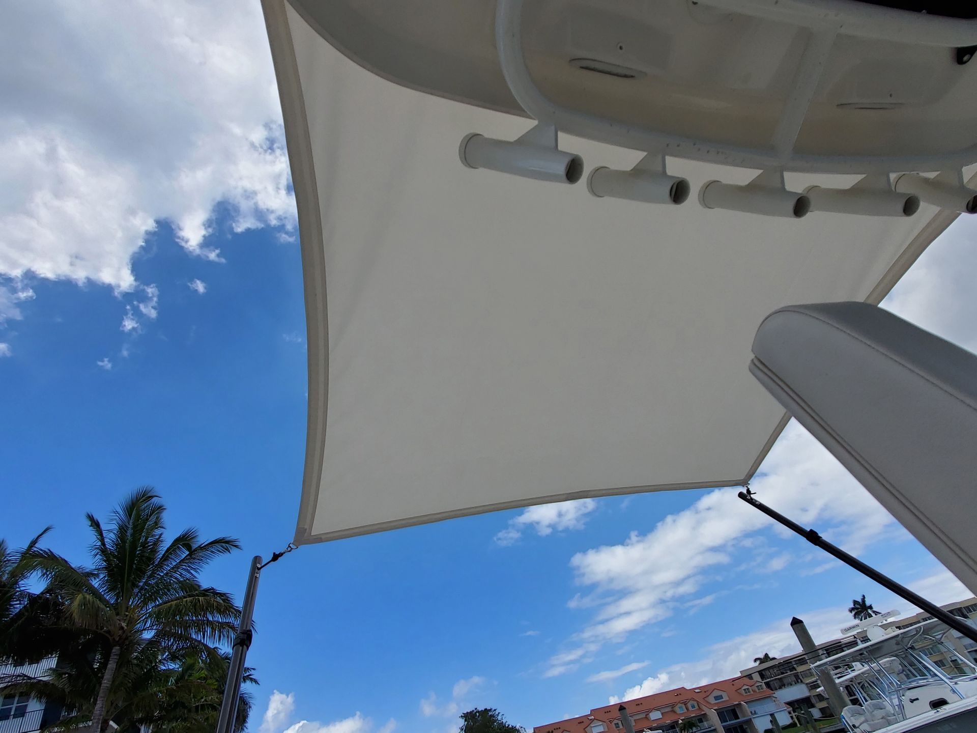 A white umbrella is hanging from the back of a boat