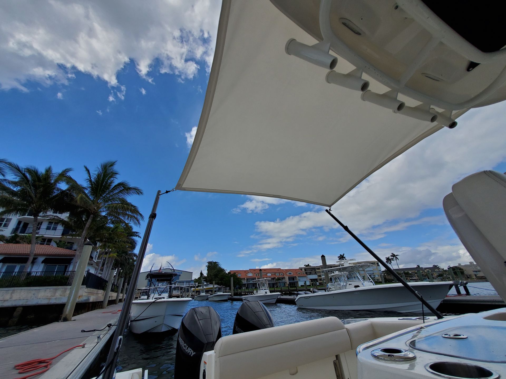 A boat with a canopy on top of it is docked in a marina.