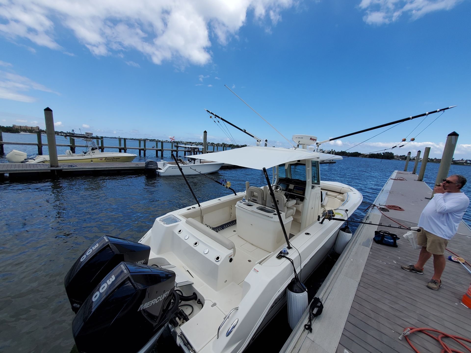 A boat is docked at a dock with a man standing next to it.
