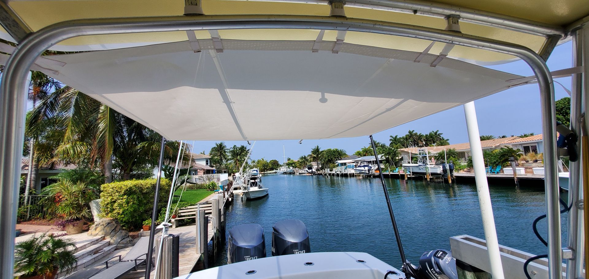 A boat is docked in a marina with a white canopy over it.