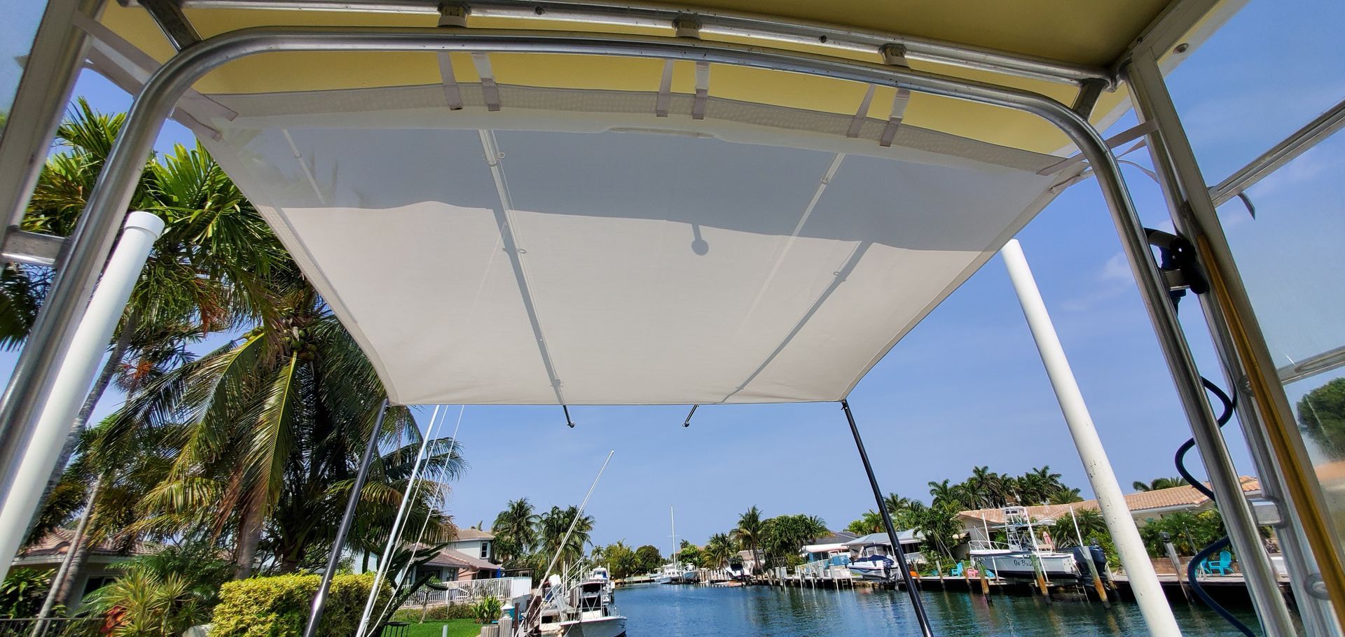 A boat with a canopy on top of it is floating on top of a body of water.