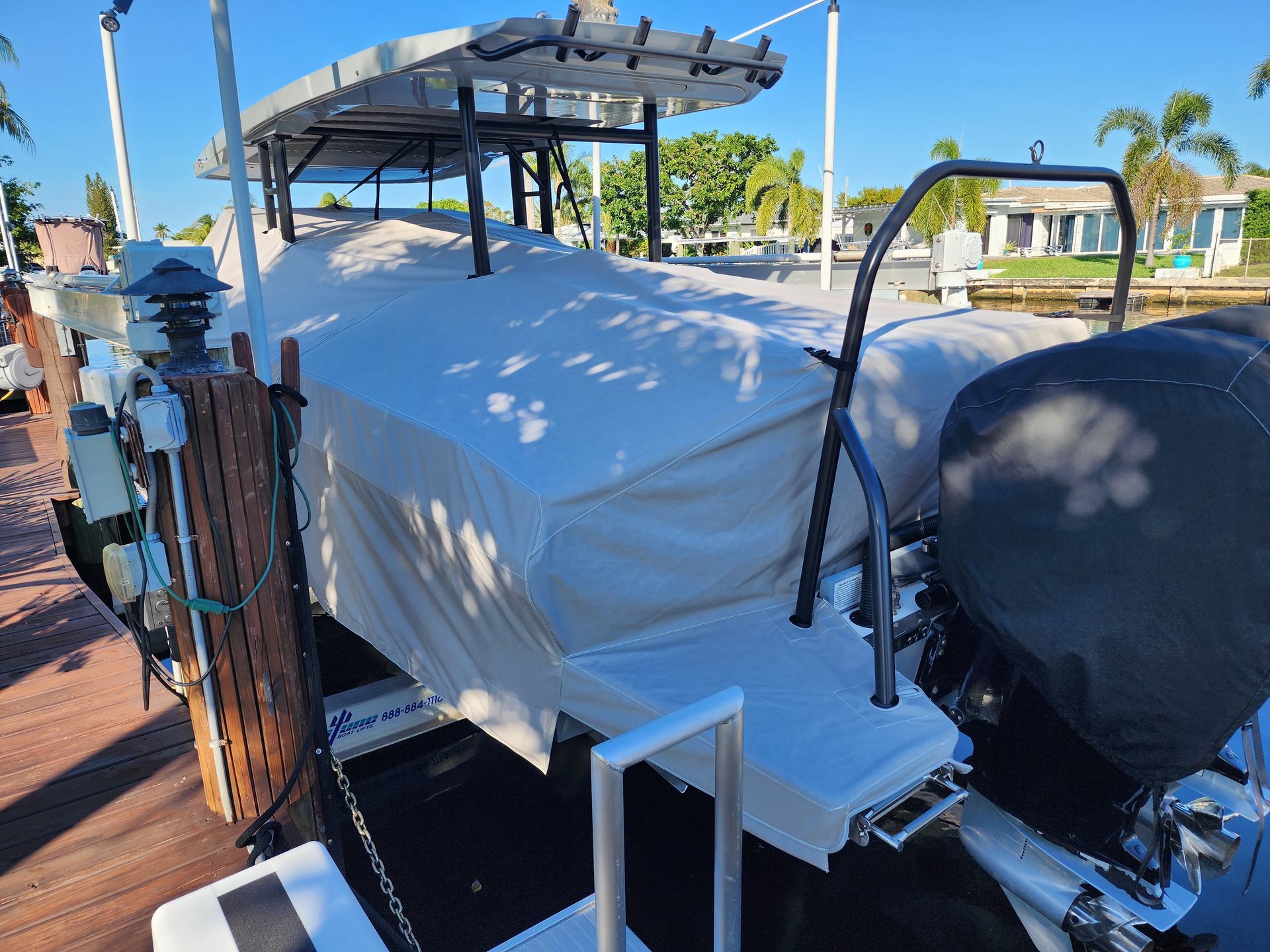 A boat is sitting on a dock with a cover on it.