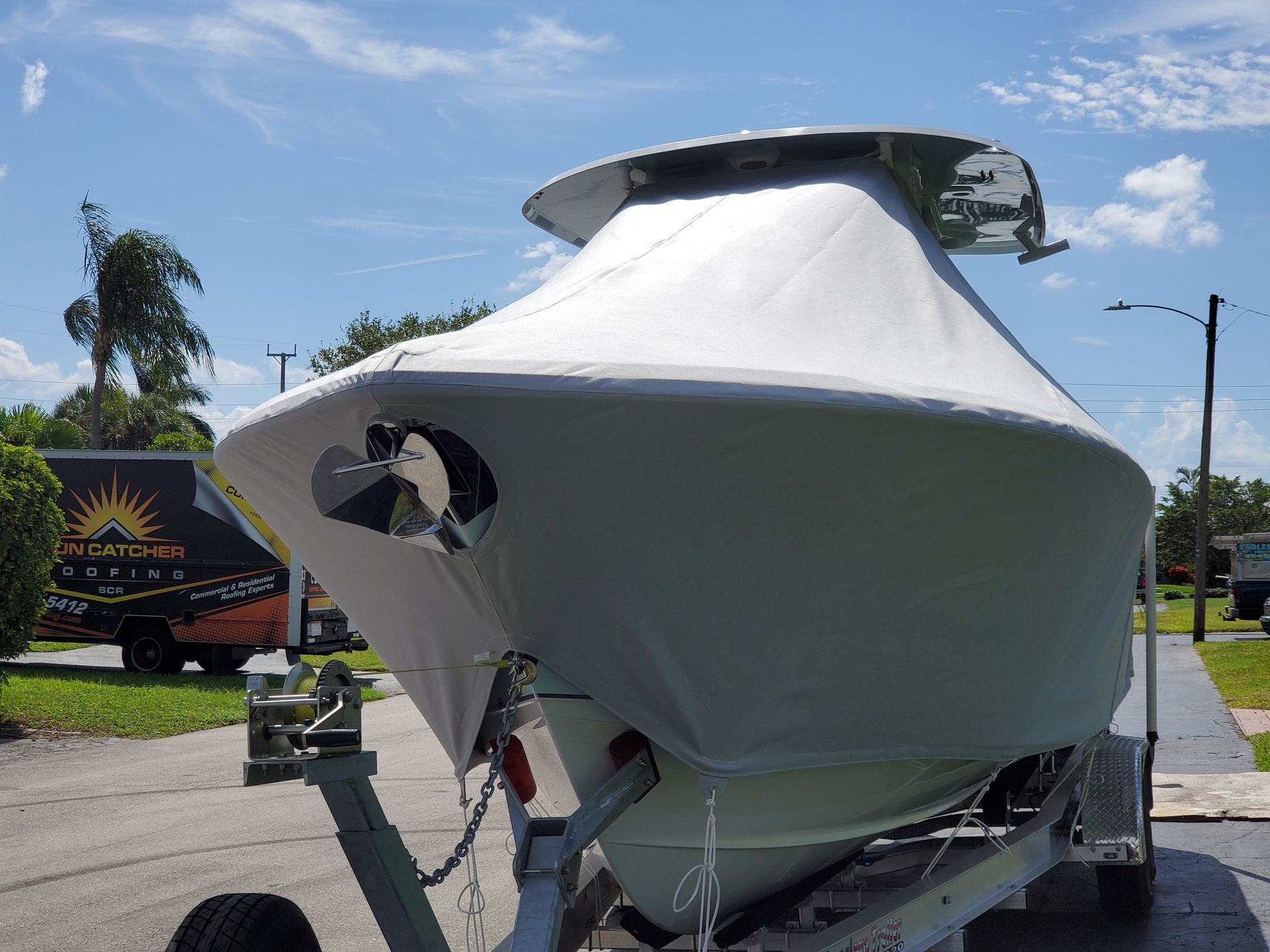 A boat on a trailer with a sunset truck in the background