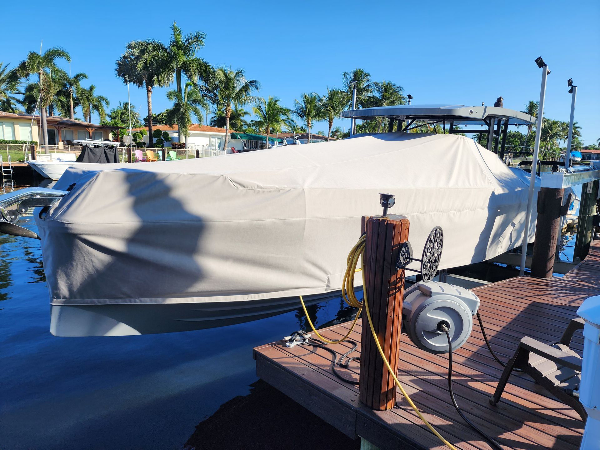 A boat with a cover on it is docked at a dock.