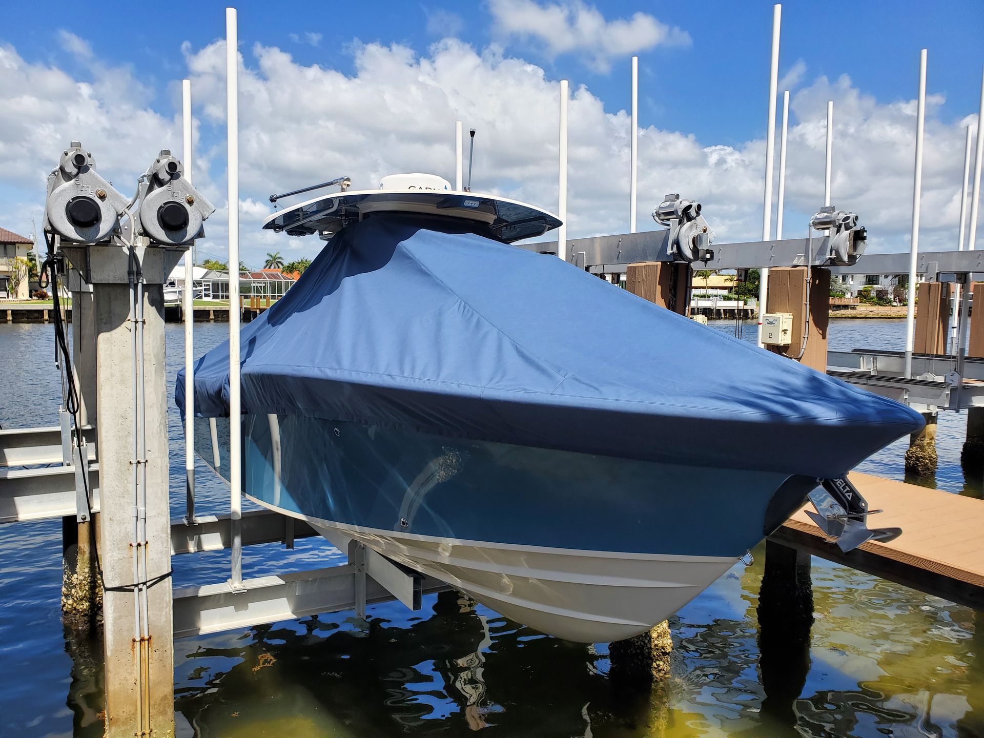 A boat is docked at a dock with a blue cover on it.