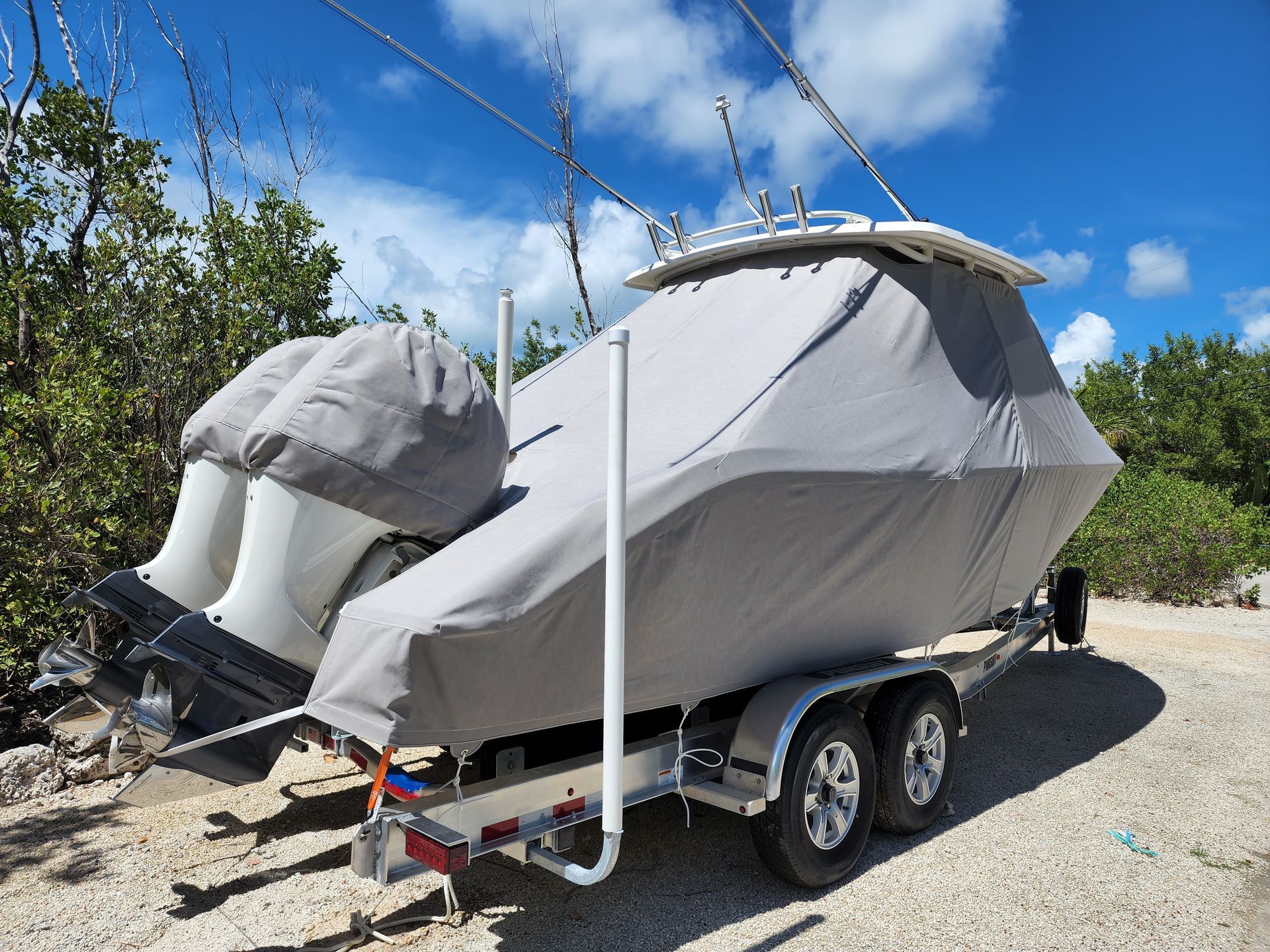 A boat with a cover on it is on a trailer.
