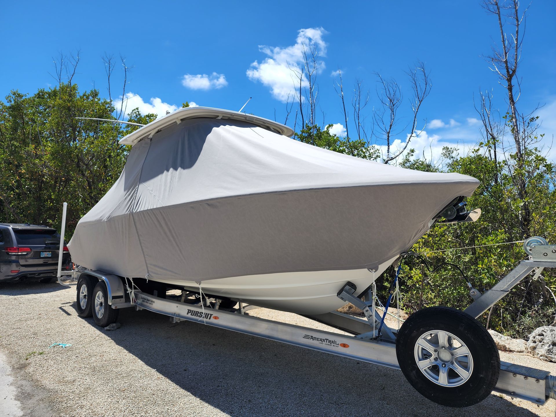 A boat on a trailer with a cover on it