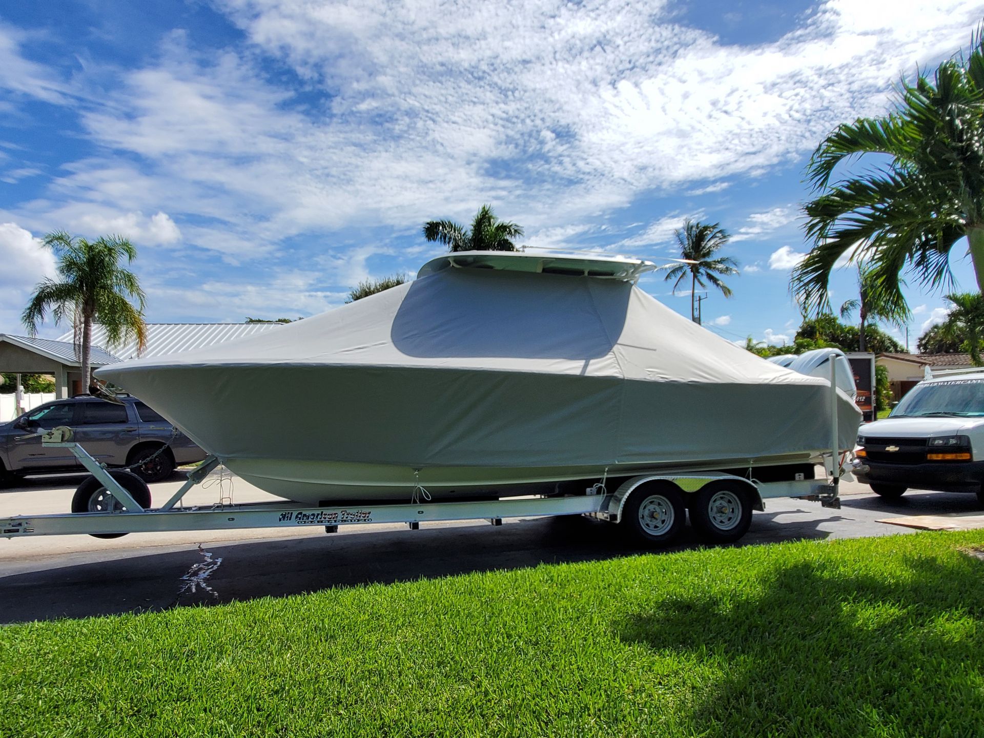 A boat is on a trailer with a cover on it.
