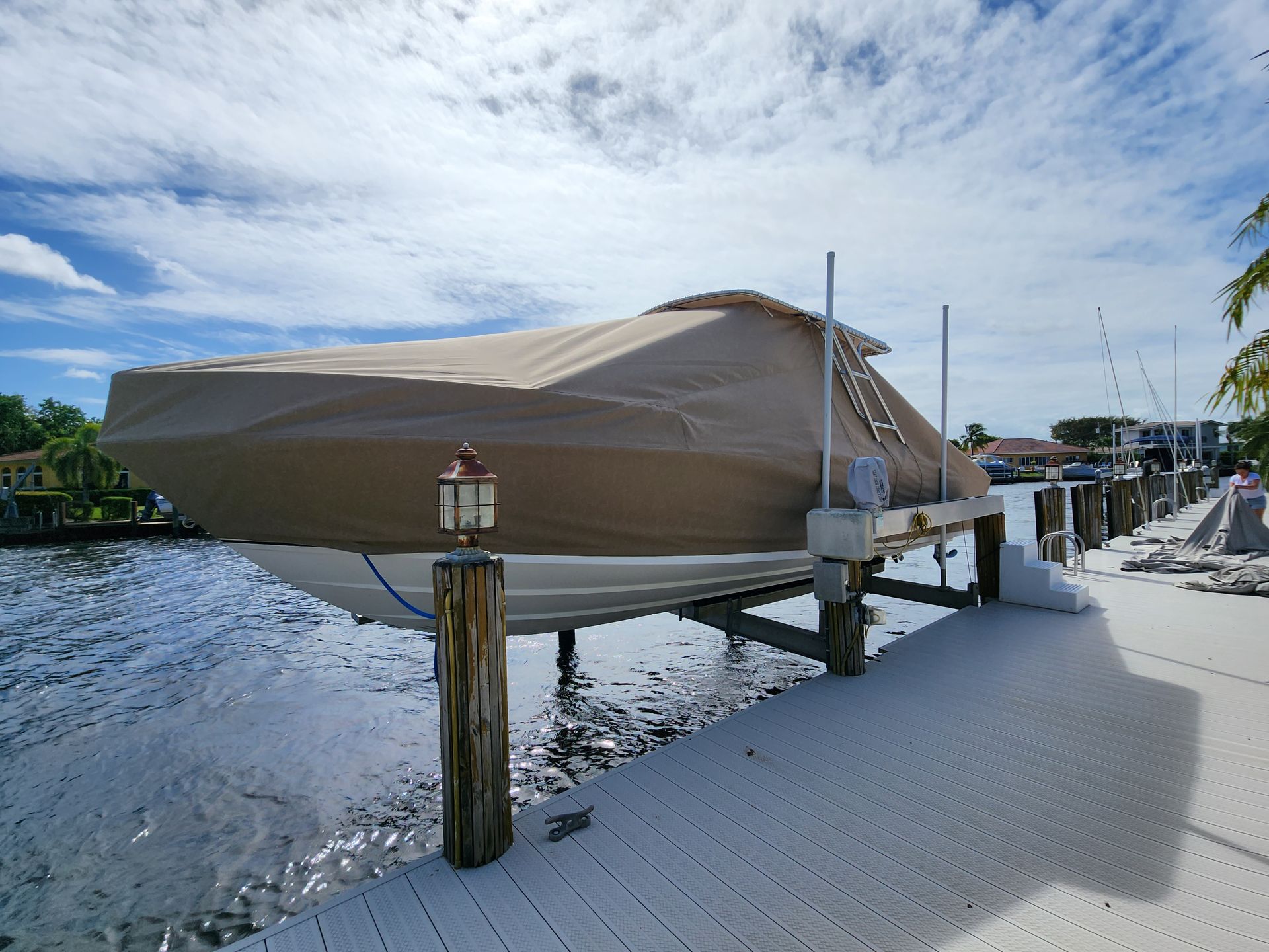 A boat is sitting on a dock with a cover on it