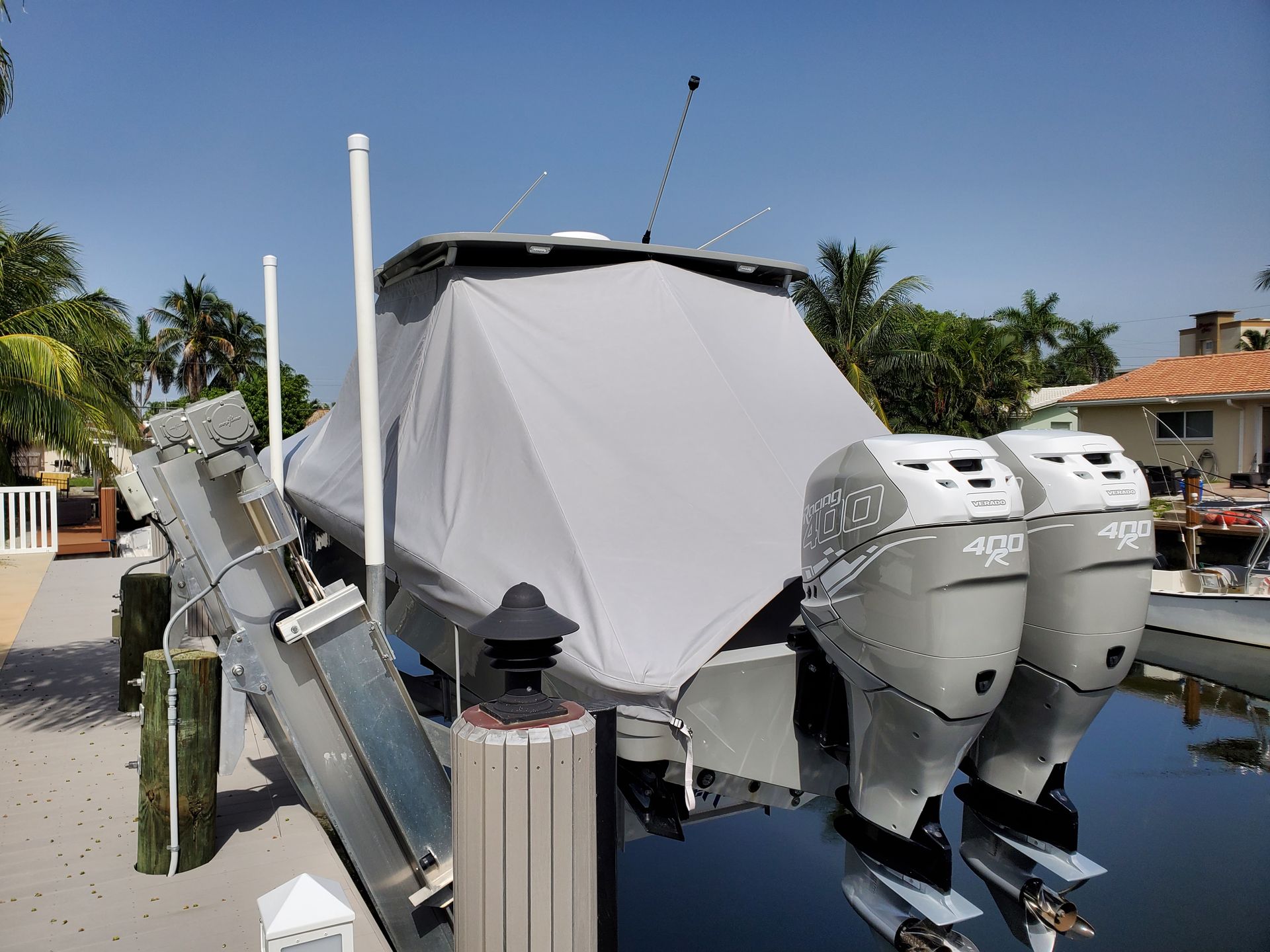 A boat with a cover on it is docked at a dock.