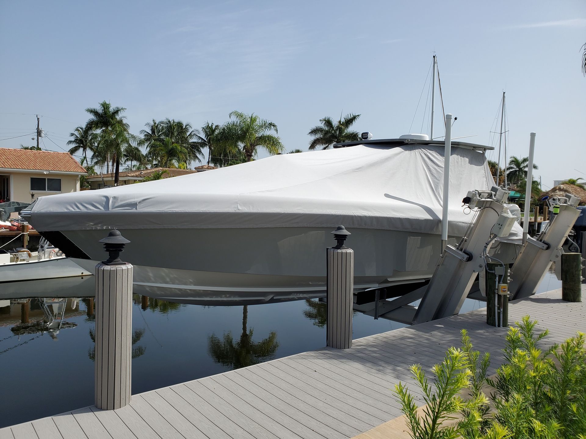 A boat with a white cover on it is docked at a dock.