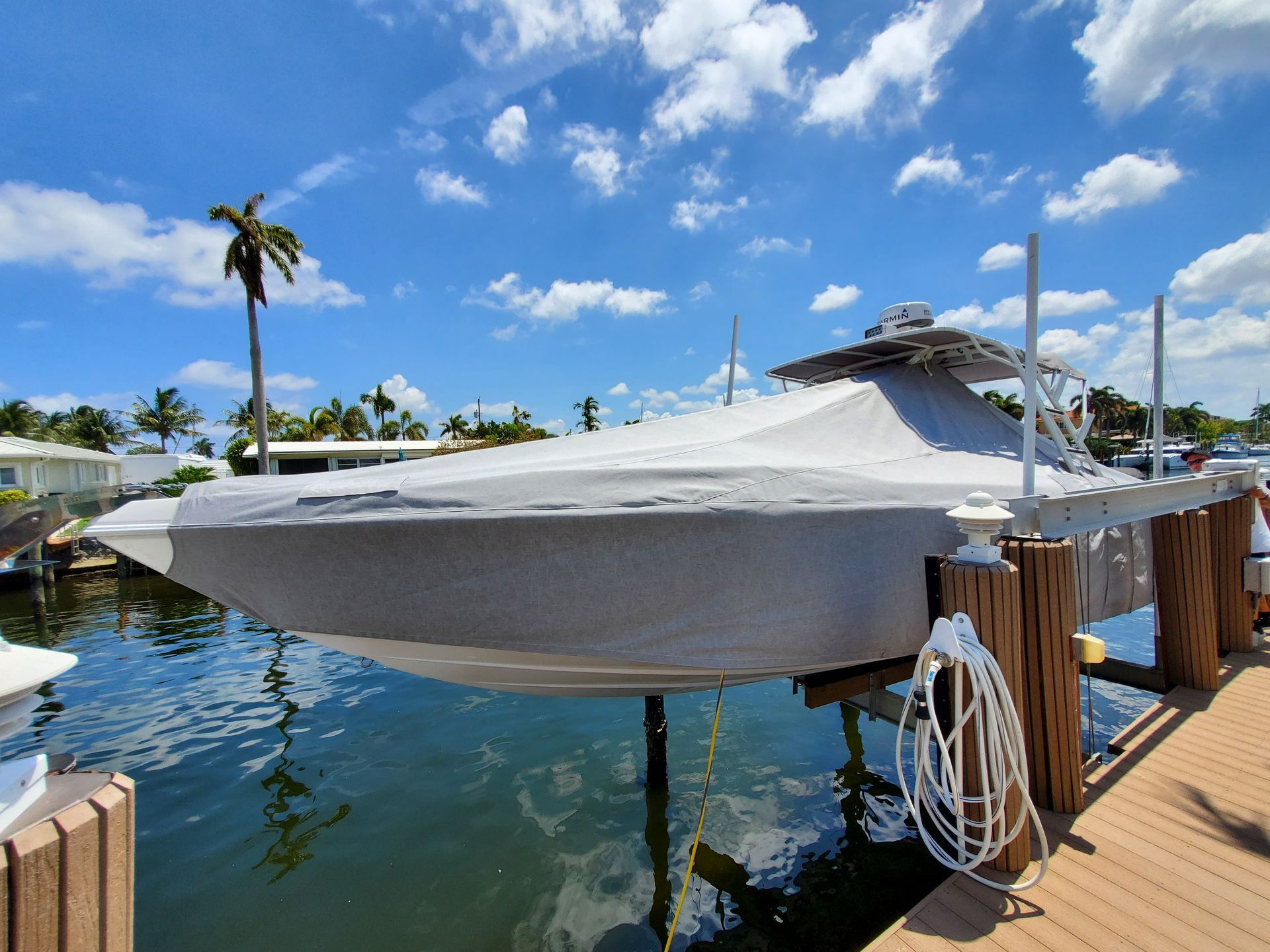 A boat is covered in a tarp and is docked at a dock.