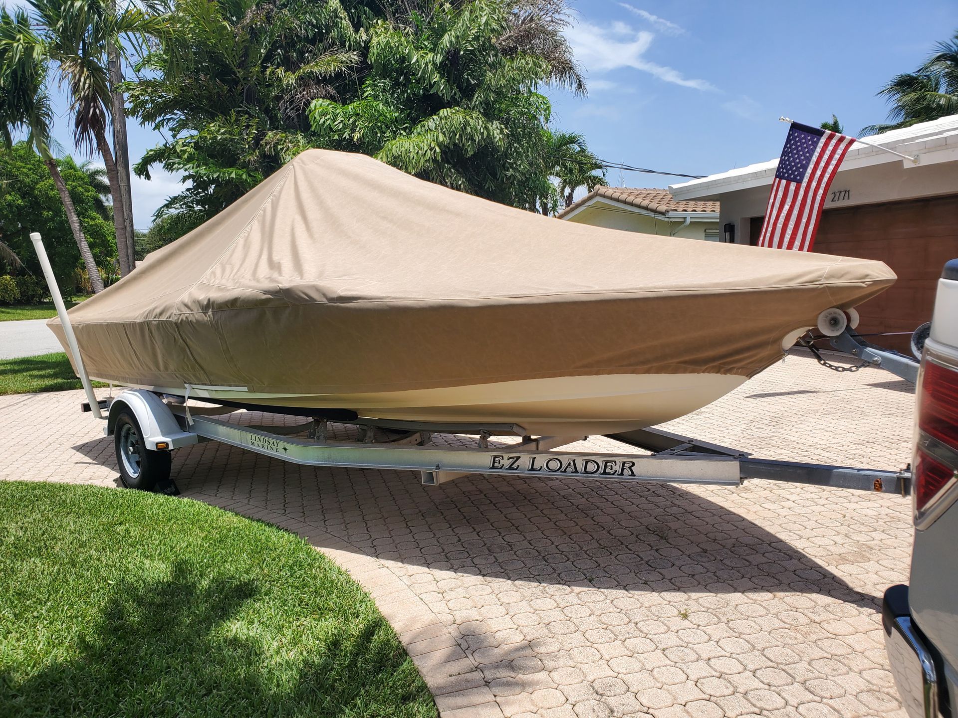 A boat with a cover on it is on a trailer.