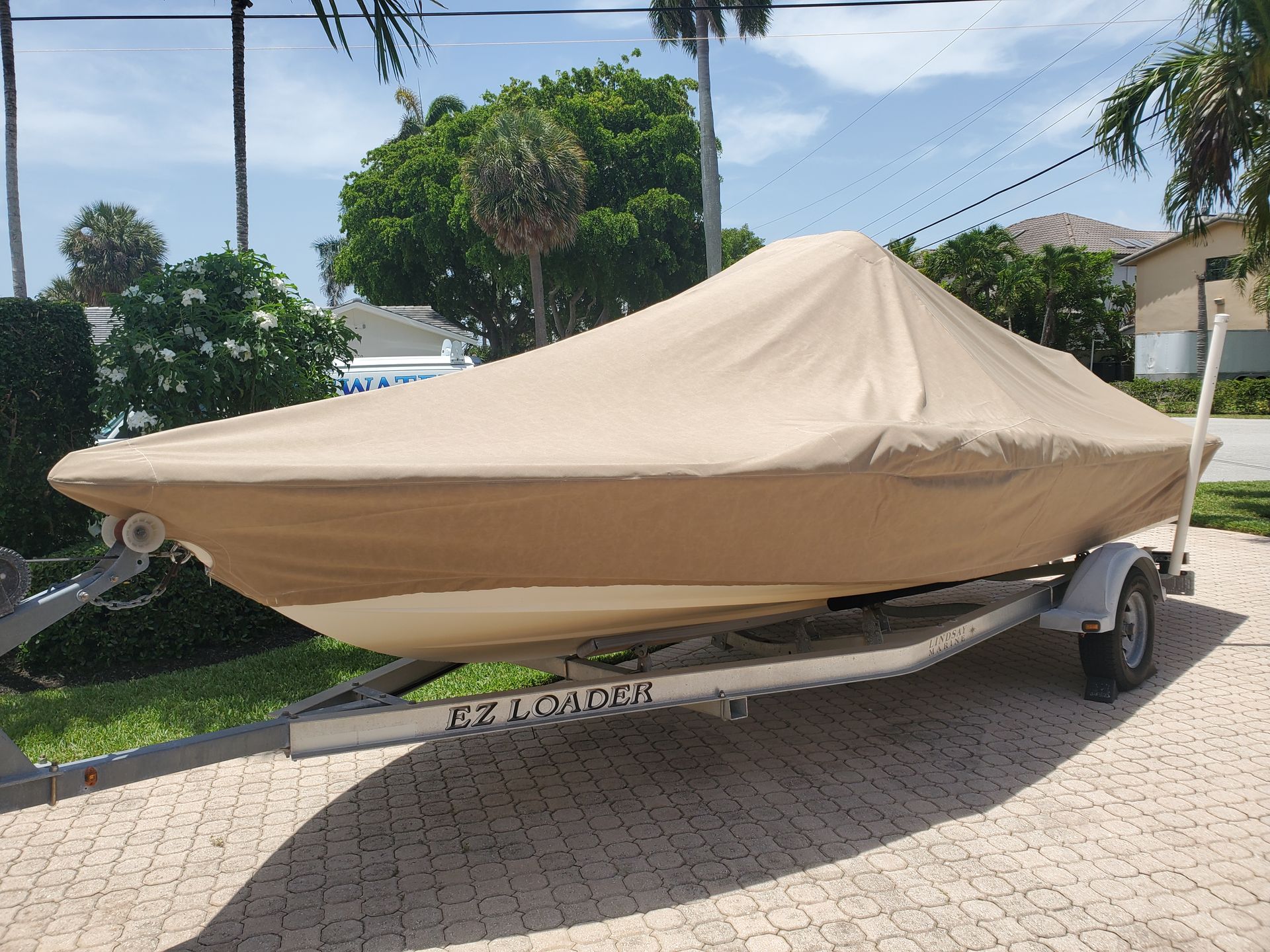 A boat with a cover on it is on a trailer