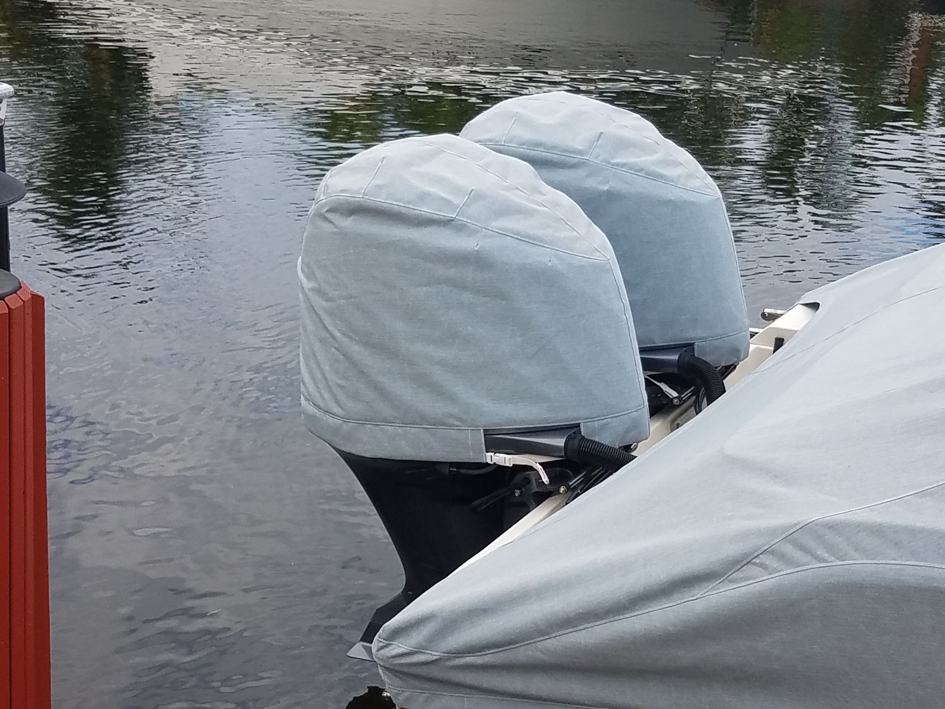 A boat with a cover on the engine is in the water