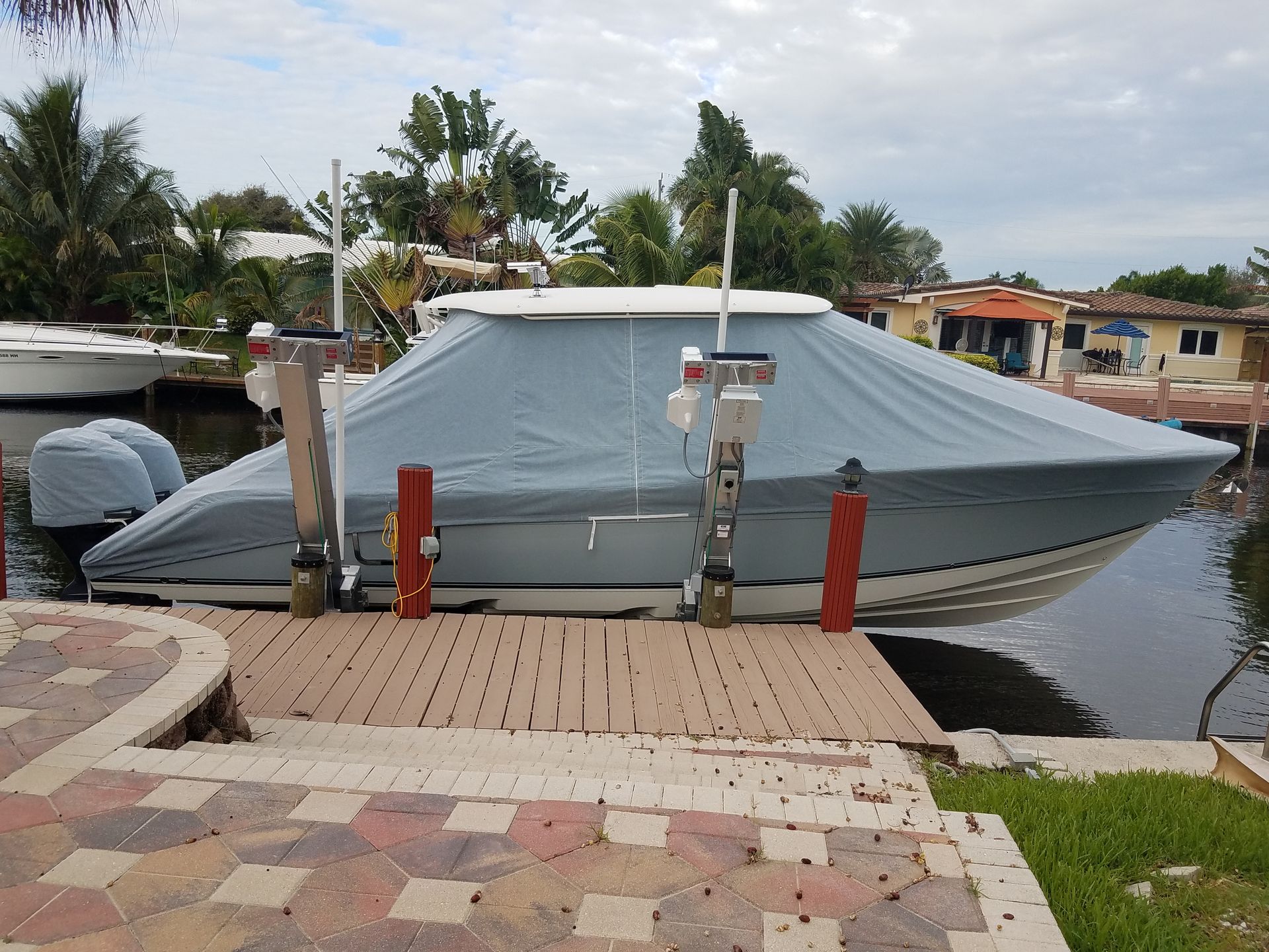 A boat with a cover on it is docked at a dock