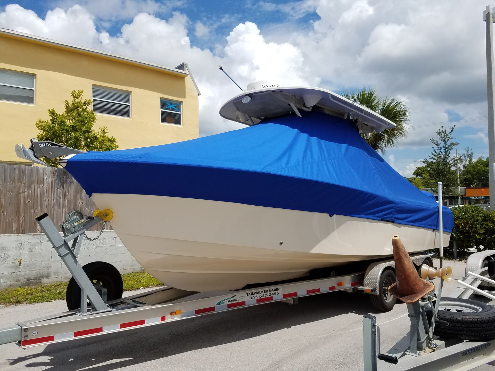 A boat on a trailer with a blue cover on it