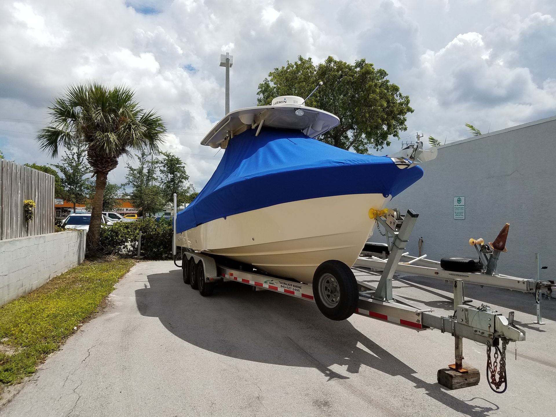 A boat on a trailer with a blue cover on it