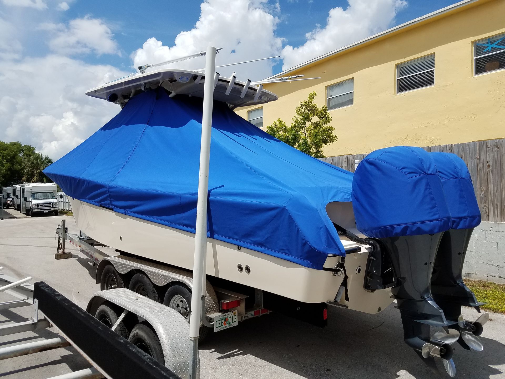A boat with a blue cover on it is on a trailer.