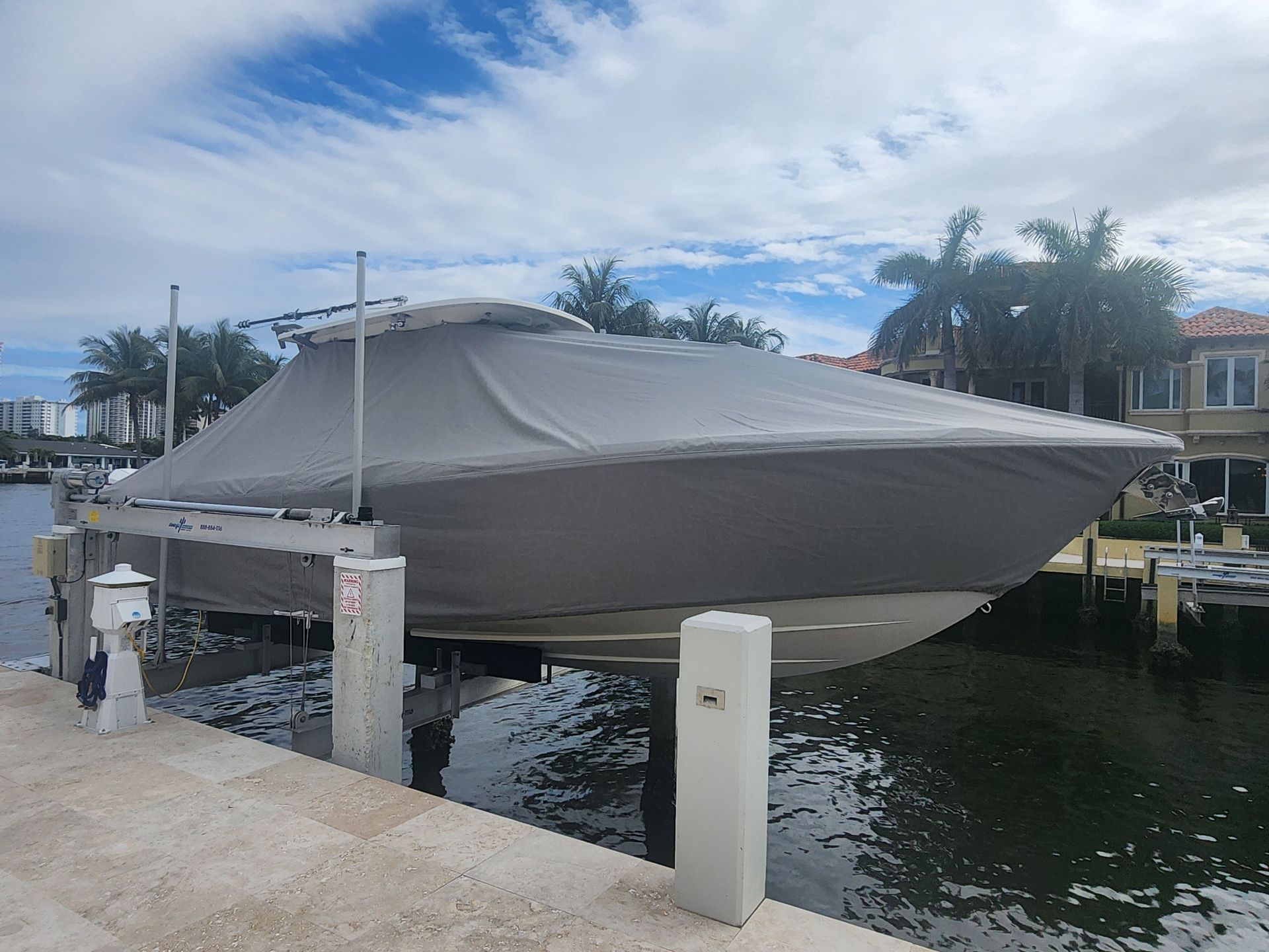 A boat with a cover on it is docked at a dock.