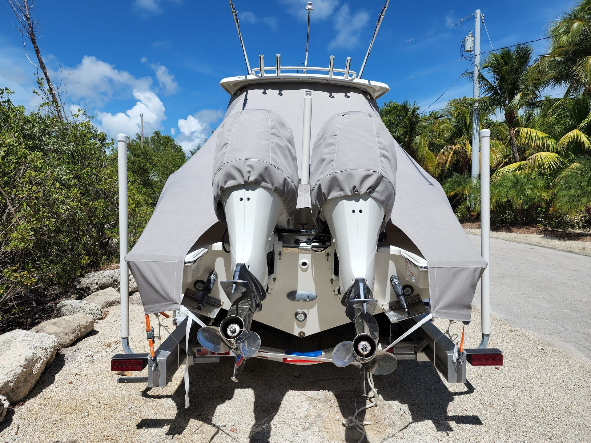 A boat is parked on a trailer on a gravel road