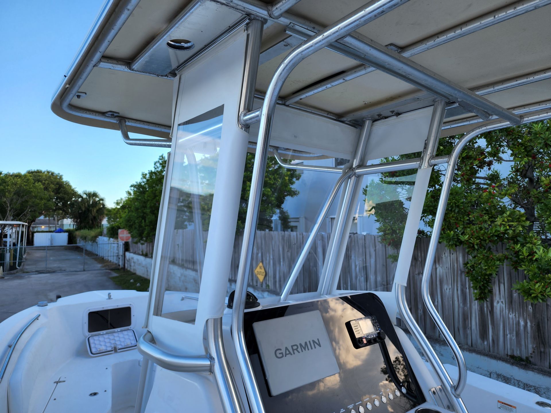 A white boat with a roof that says garmin on it