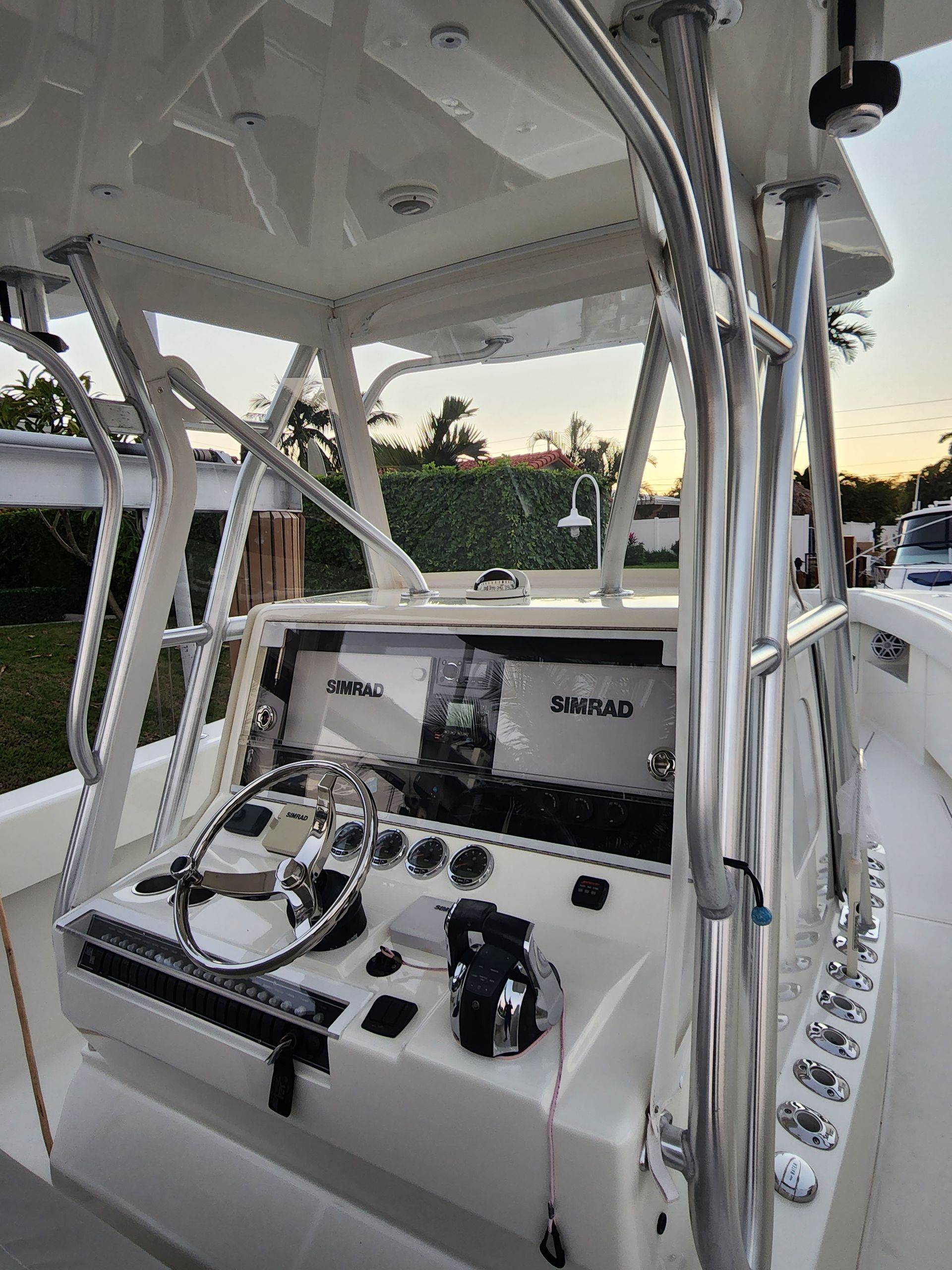 The cockpit of a white boat with a steering wheel.