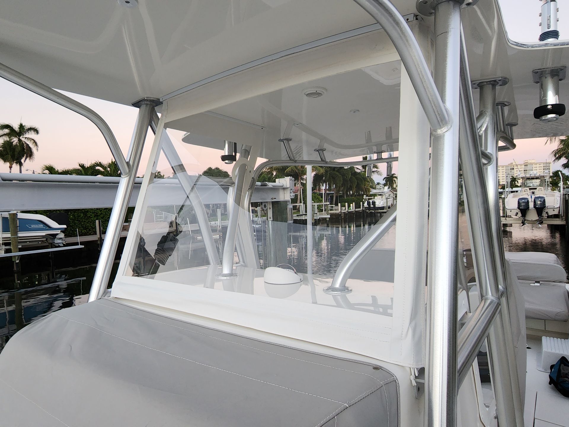 A boat with a clear windshield is docked at a marina.