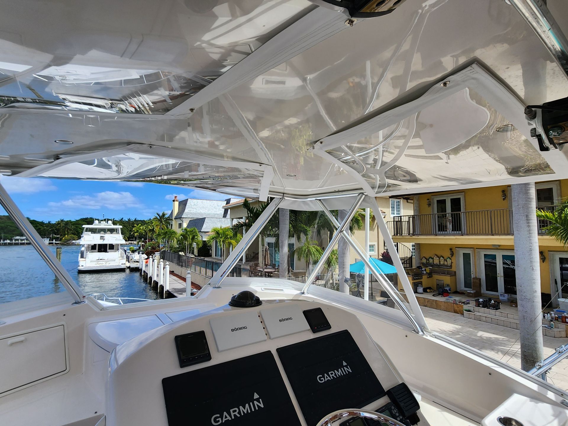 The inside of a boat with a steering wheel and a canopy.