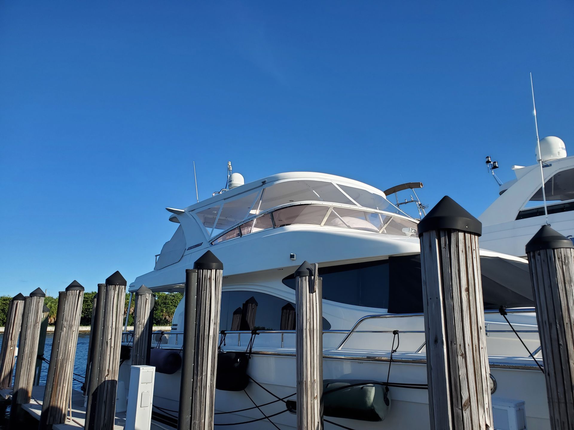A large white yacht is docked at a dock