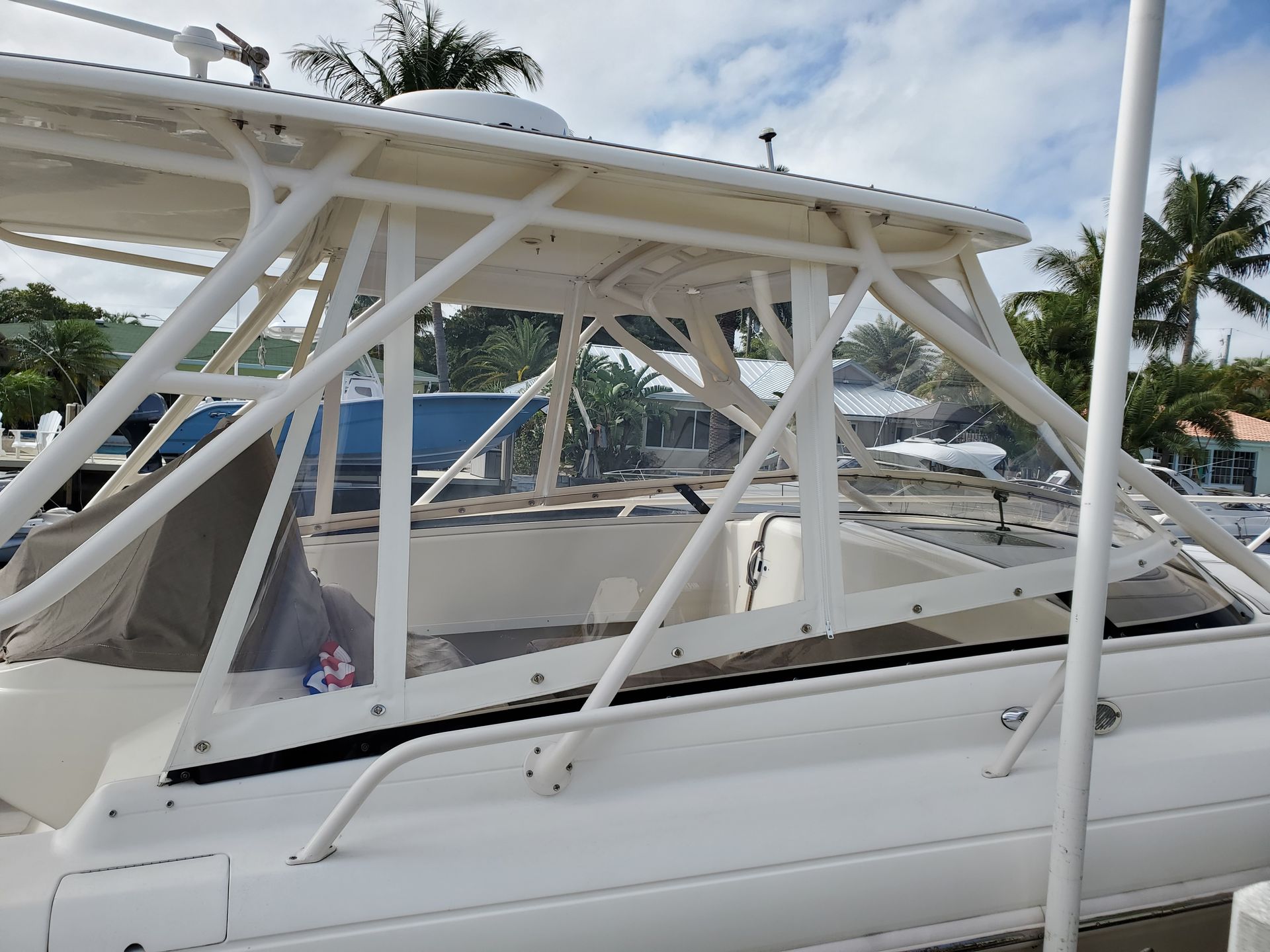 A white boat with a clear roof is parked in a dock.