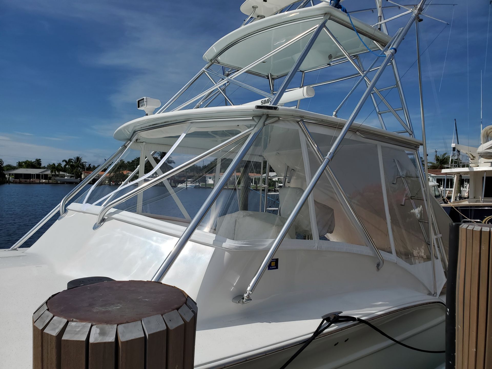 A large white boat is docked at a marina