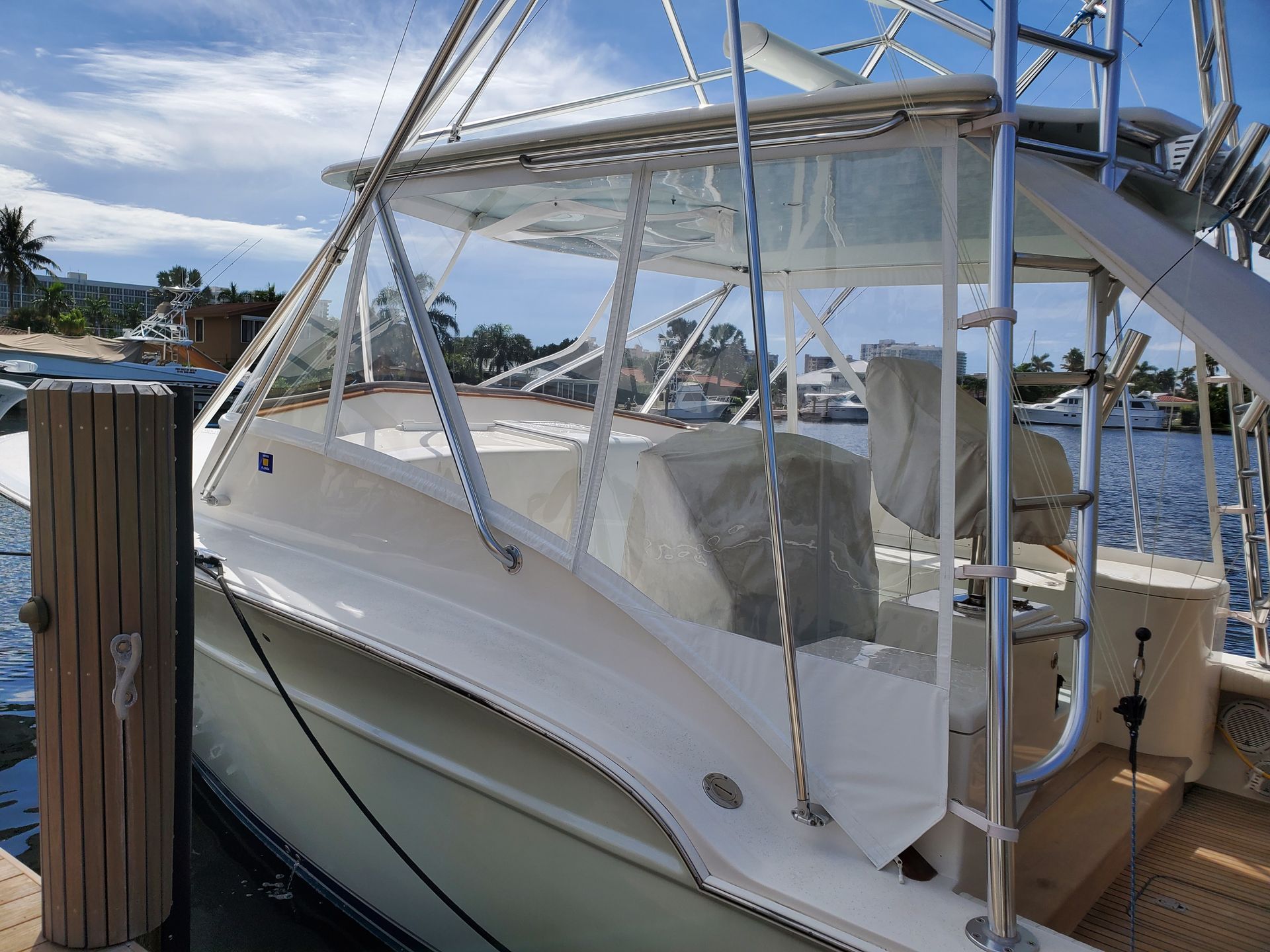 A white boat is docked at a dock in the water