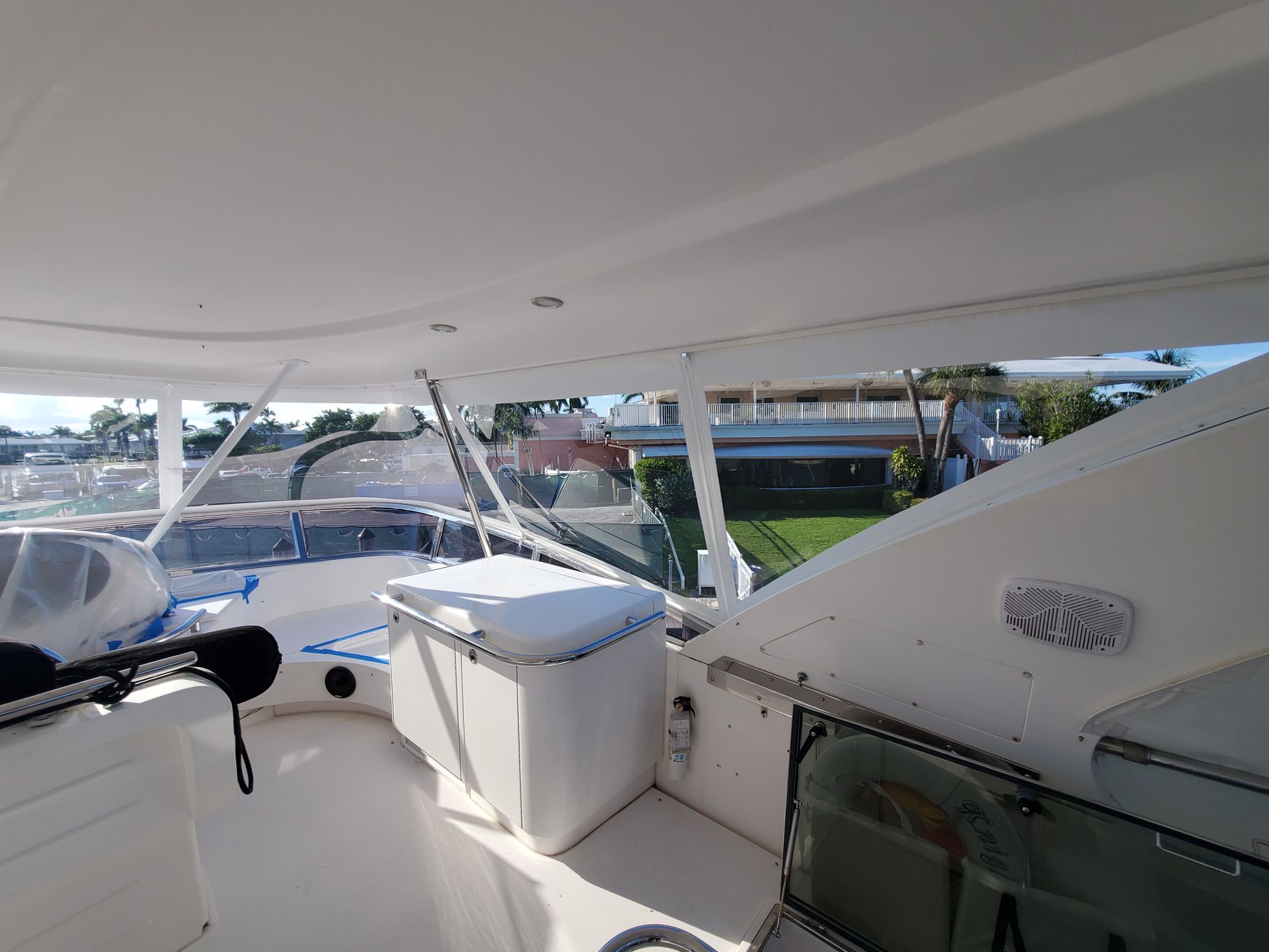 The inside of a white boat with a cooler on the deck.