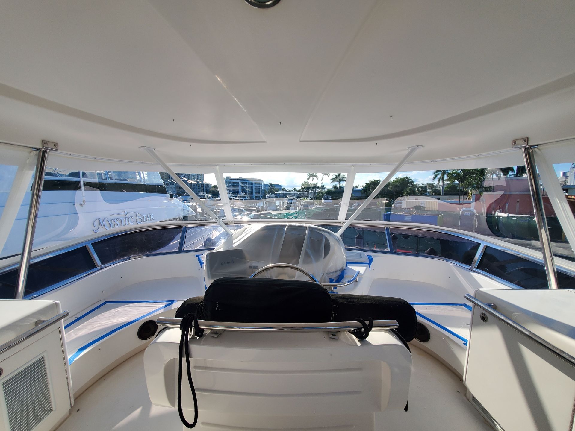 A white boat with a black seat and a steering wheel