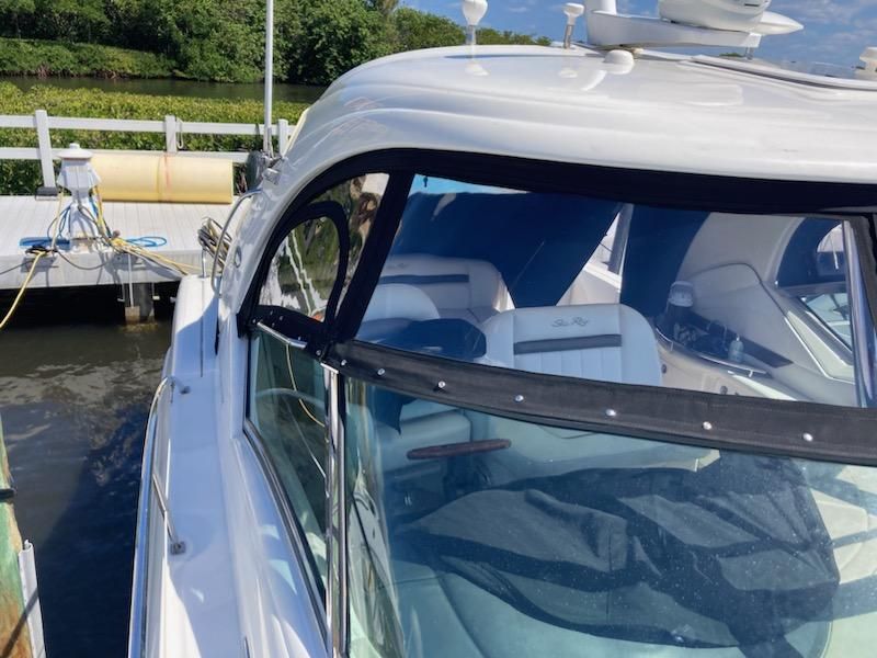 A white boat is docked at a dock next to a body of water.