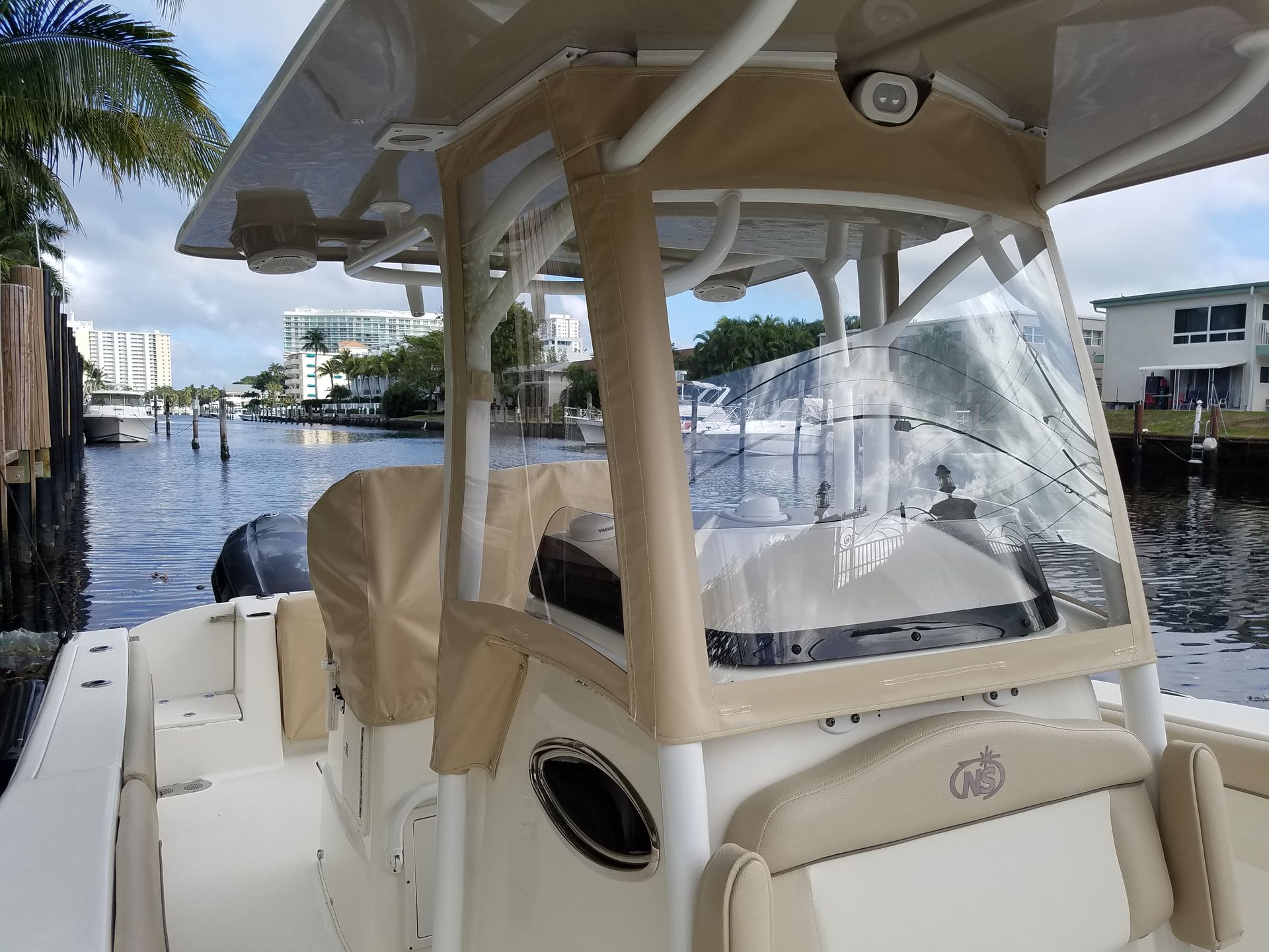 A white boat with a clear windshield is in the water