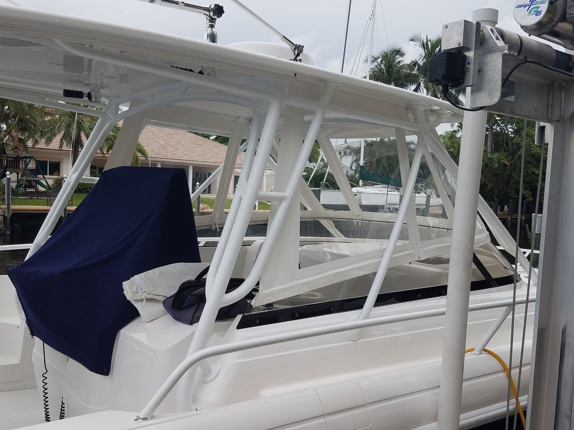 A white boat with a blue cover on the cockpit