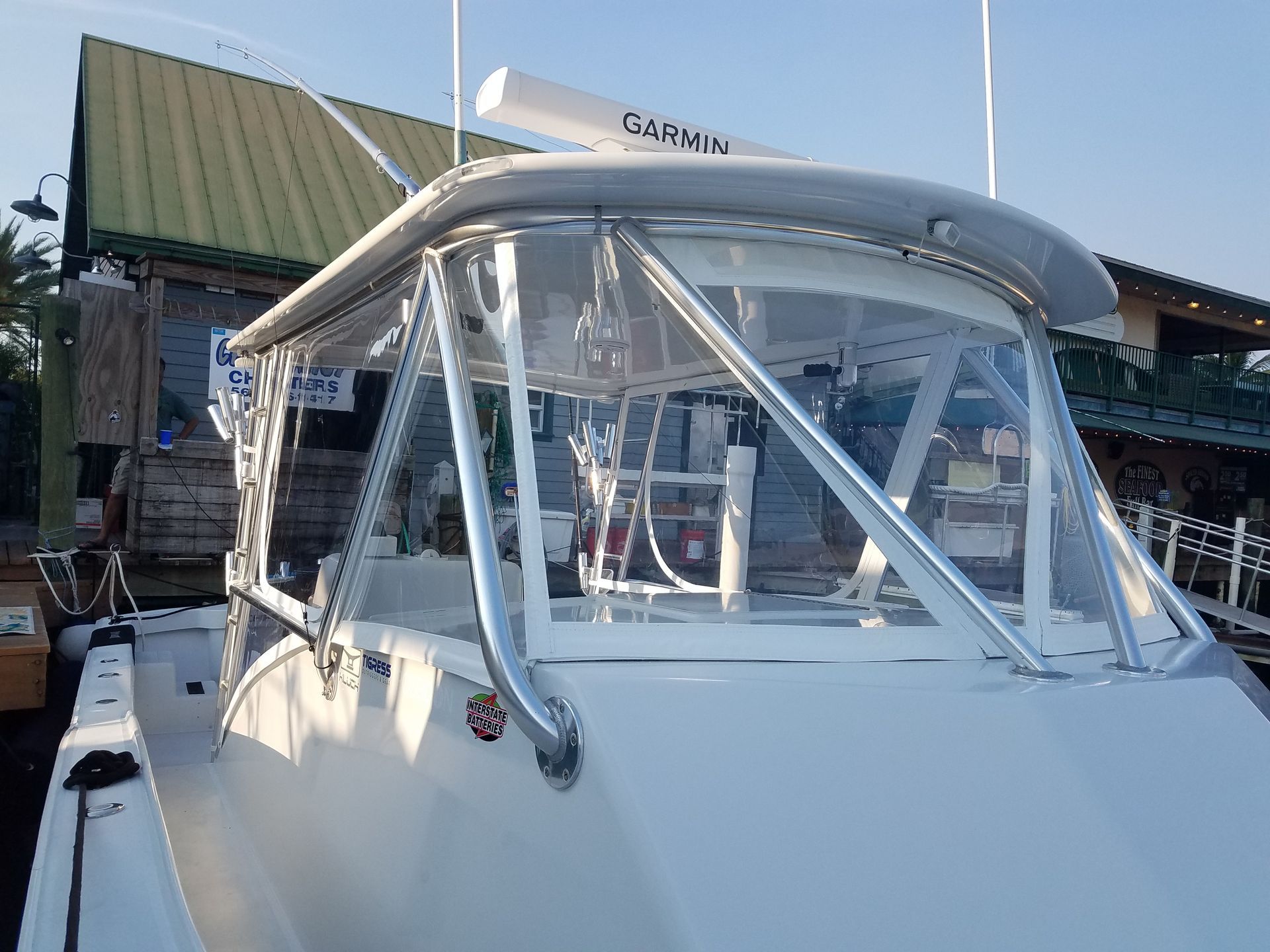 A boat is docked at a dock with a canopy over it