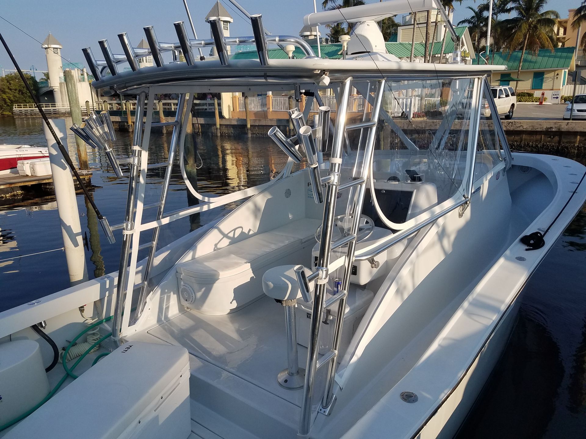 A large white boat is docked in a marina