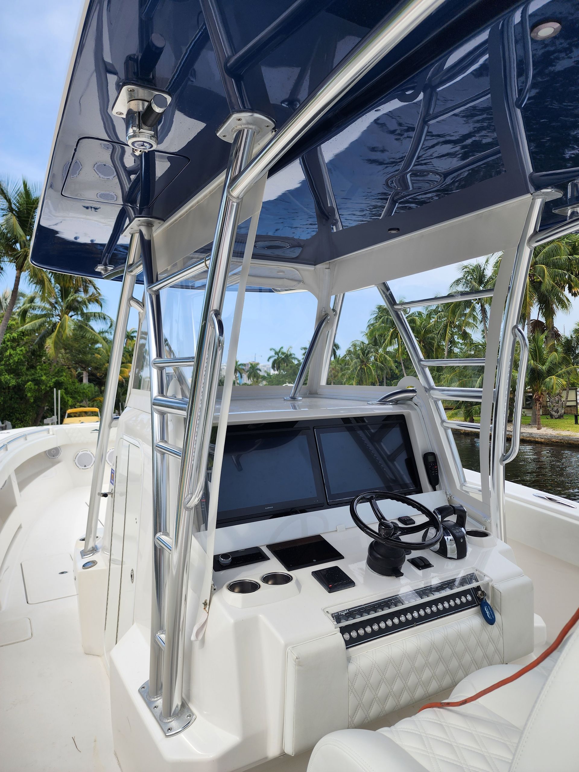A white boat with a blue roof and a steering wheel