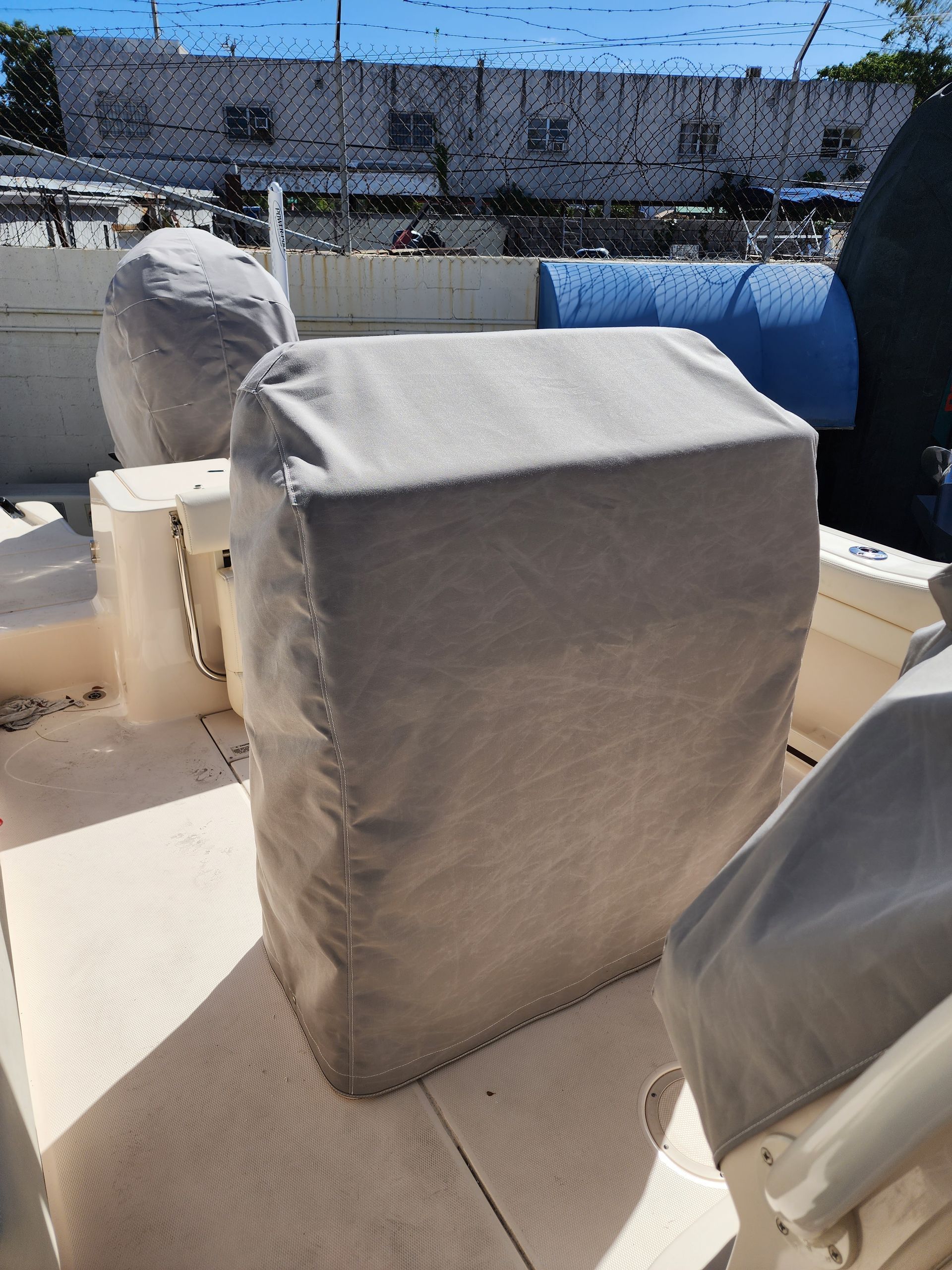 A boat with a cover on the seats and steering wheel.